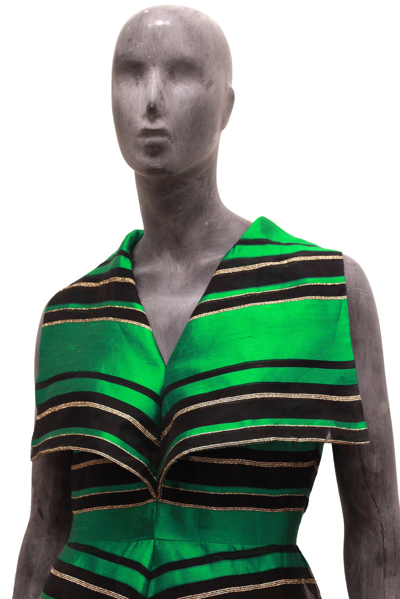 An exceptional 1960s Anne Gerrard couture evening dress made on the prestigious Bond St, London. The dress is in a green silk organza with a gold thread trimming. The black semi sheer chiffon panels and oversize collar add drama and sex appeal to