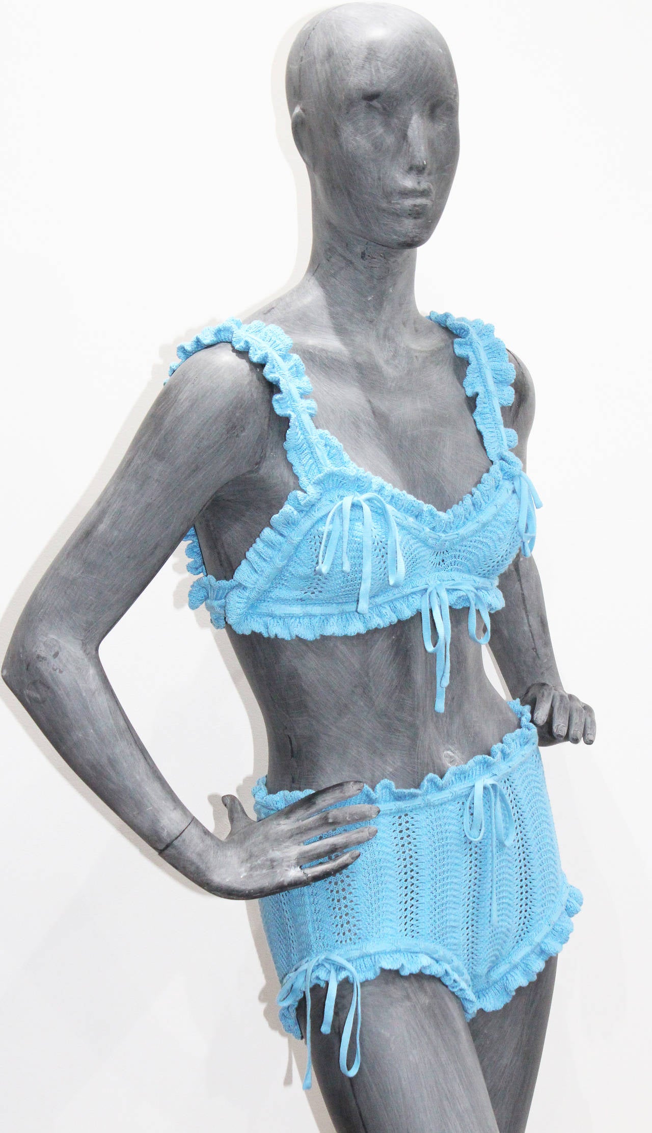 A rare Vivienne Westwood crochet knitted 2 piece bikini from the 'On Liberty' A/W 1994 collection. 

The suit has frilled trim, lace up bows and made of 100% cotton in baby blue.

Size Small - UK 6-8 / FR 34-36