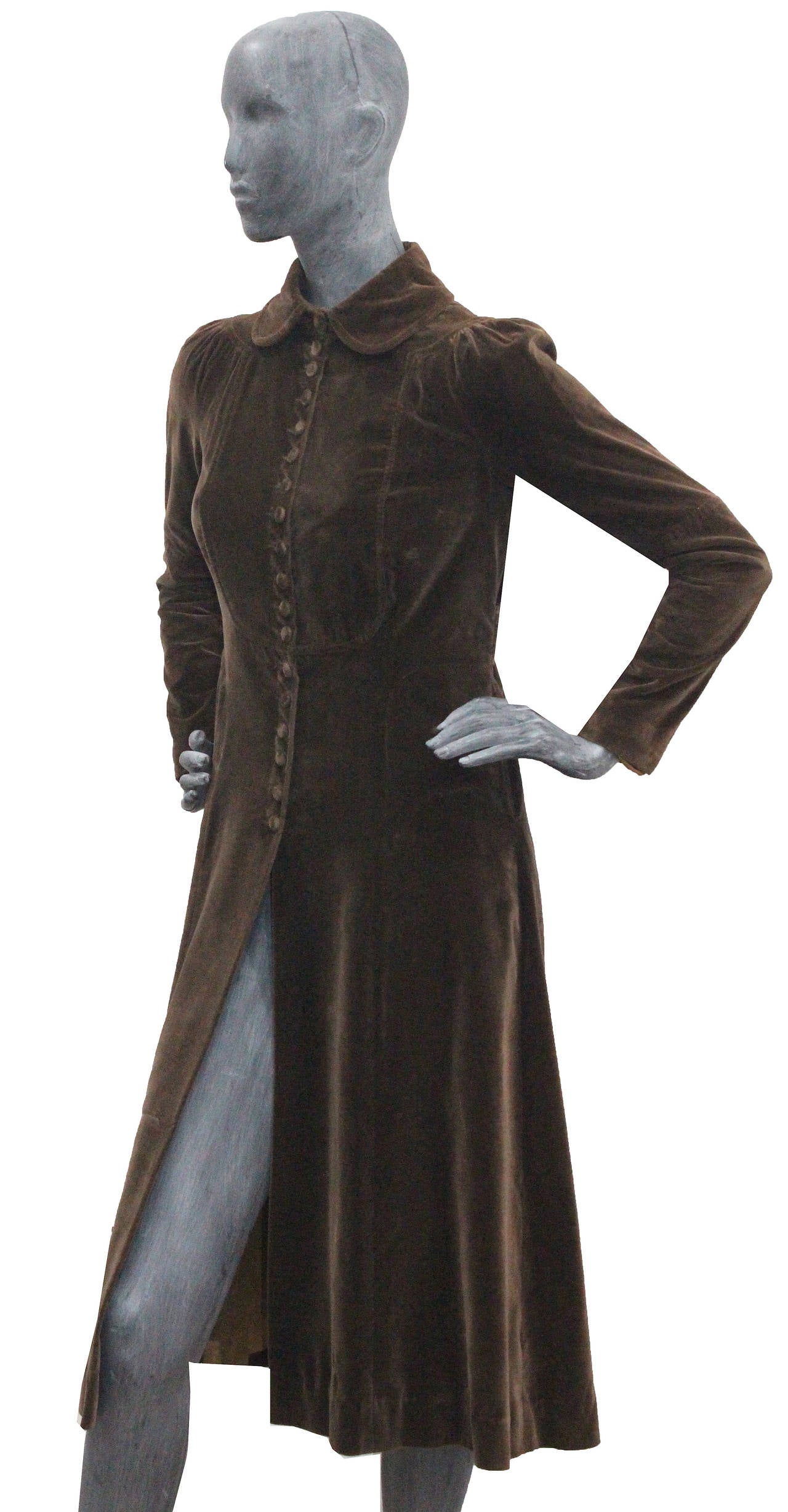 A fine and rare Ossie Clark brown velvet coat made exclusively for Bonwit Teller (New York, U.S.A.). The coat has a pleated back with a hanging belt, pleated fitted sleeves, two hidden open front pockets and velvet fabric buttons running through the