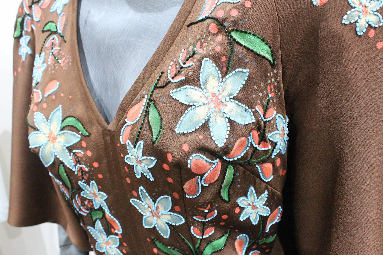 A very rare and fine hand painted and hand beaded brown silk crepe evening gown with attached cape. The dress was designed by Douglass Darnell for a very special client in the early 1970s. 

Douglass Darnell was a London based couturier and