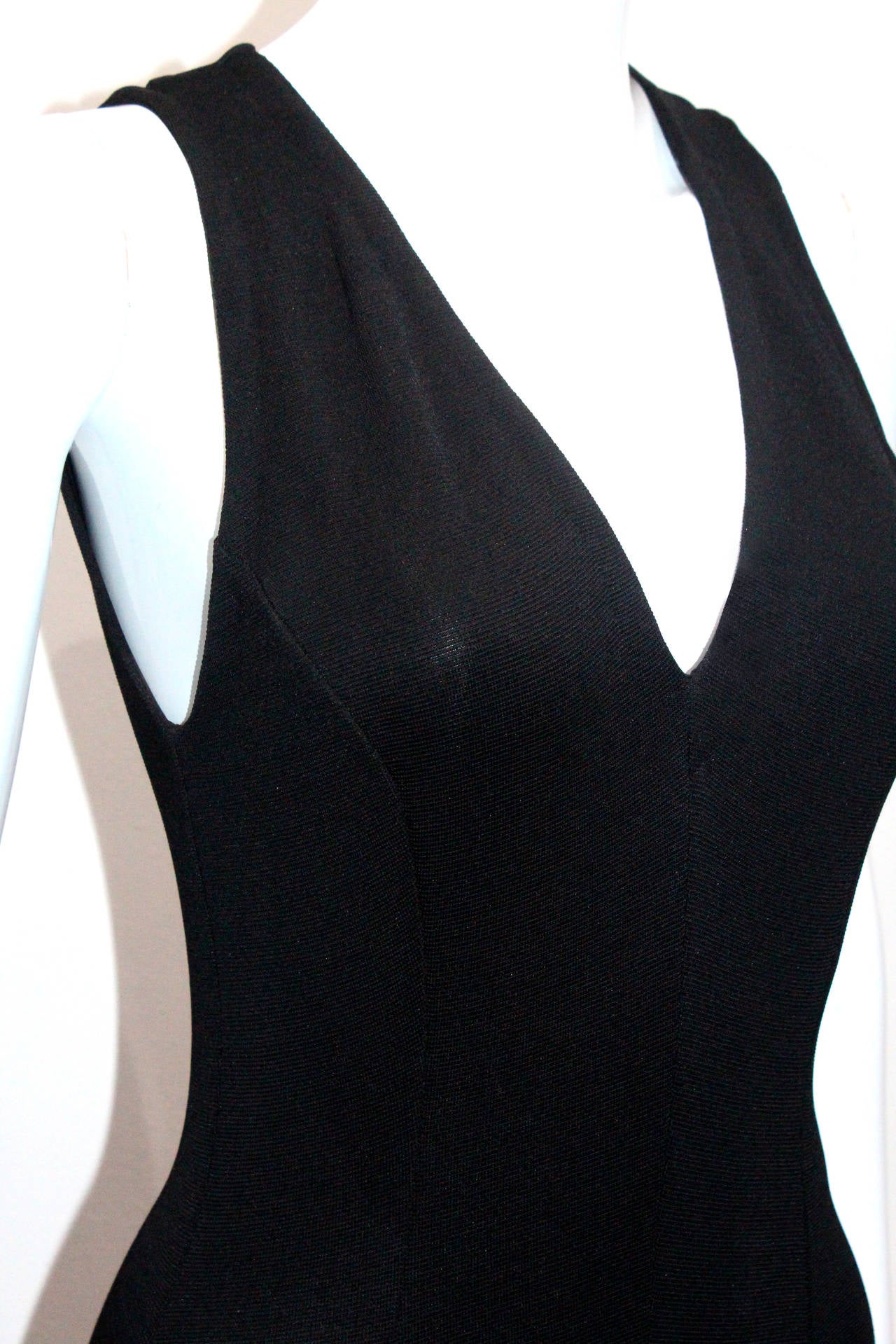 A black fitted jumpsuit by Gianni Versace with flared trousers. 

The fabric is unknown but very body conscious and stretchy.

Italian 40 / French 36 / UK 8 / US 6