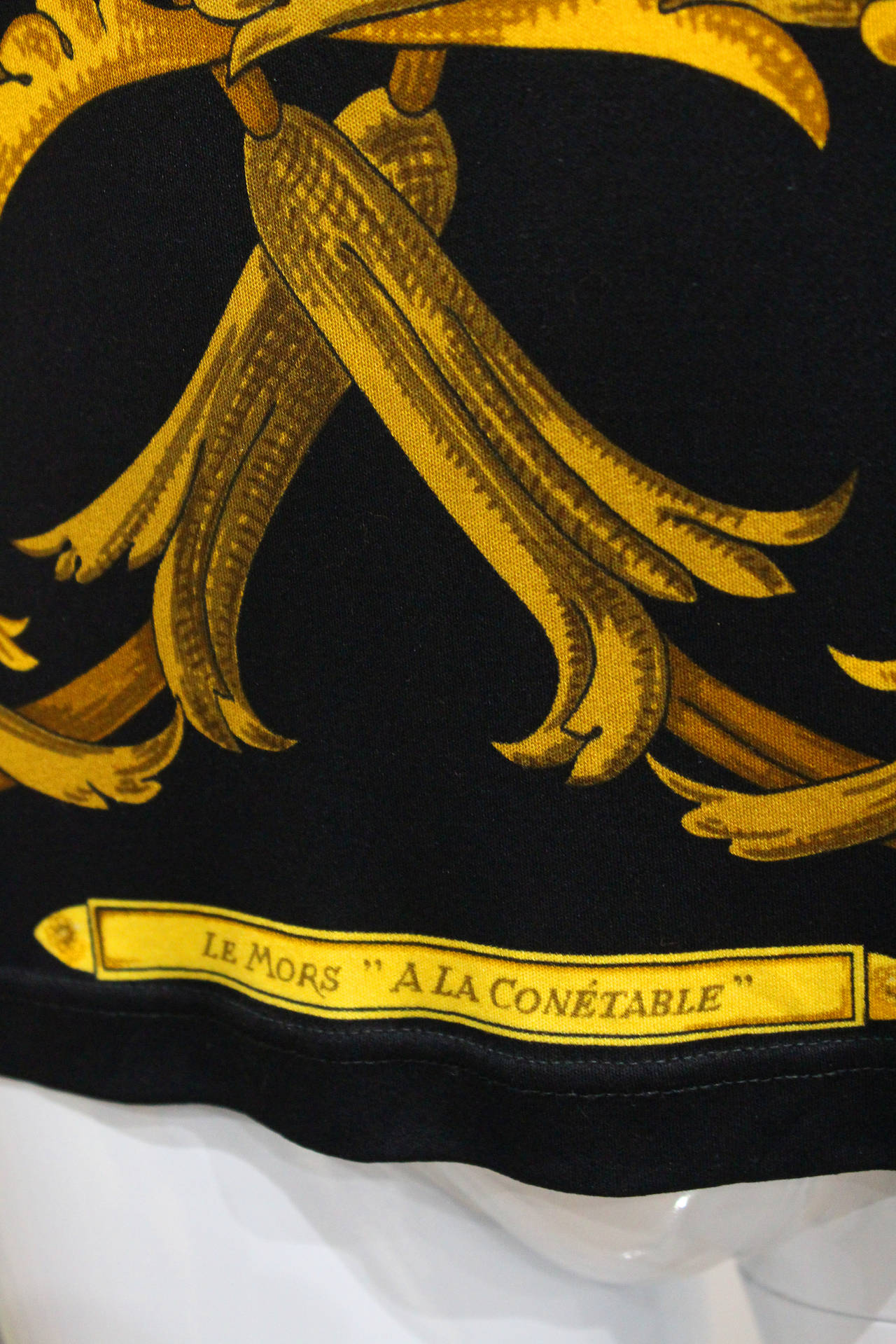 A rare silk jersey blouse by HERMES PARIS from the 1980s with a 'Le Mors à la Conétable' print in black and gold designed by artist Henri d'Origny. 

Size Small