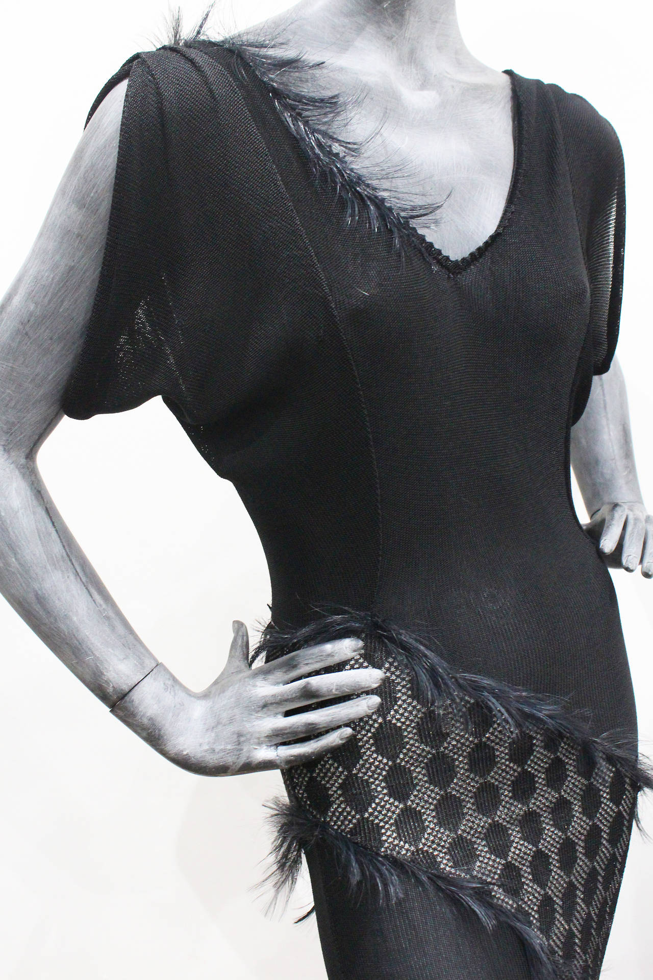 A viscose and lurex evening knit dress by British knitwear designer Julien Macdonald, designed in the 1990s. The dress is cut on the bias and has black feathers appearing on the seams. 

SIZING: Small Approx. EU 34 - 36 / UK 6 - 8 / US 4 - 6