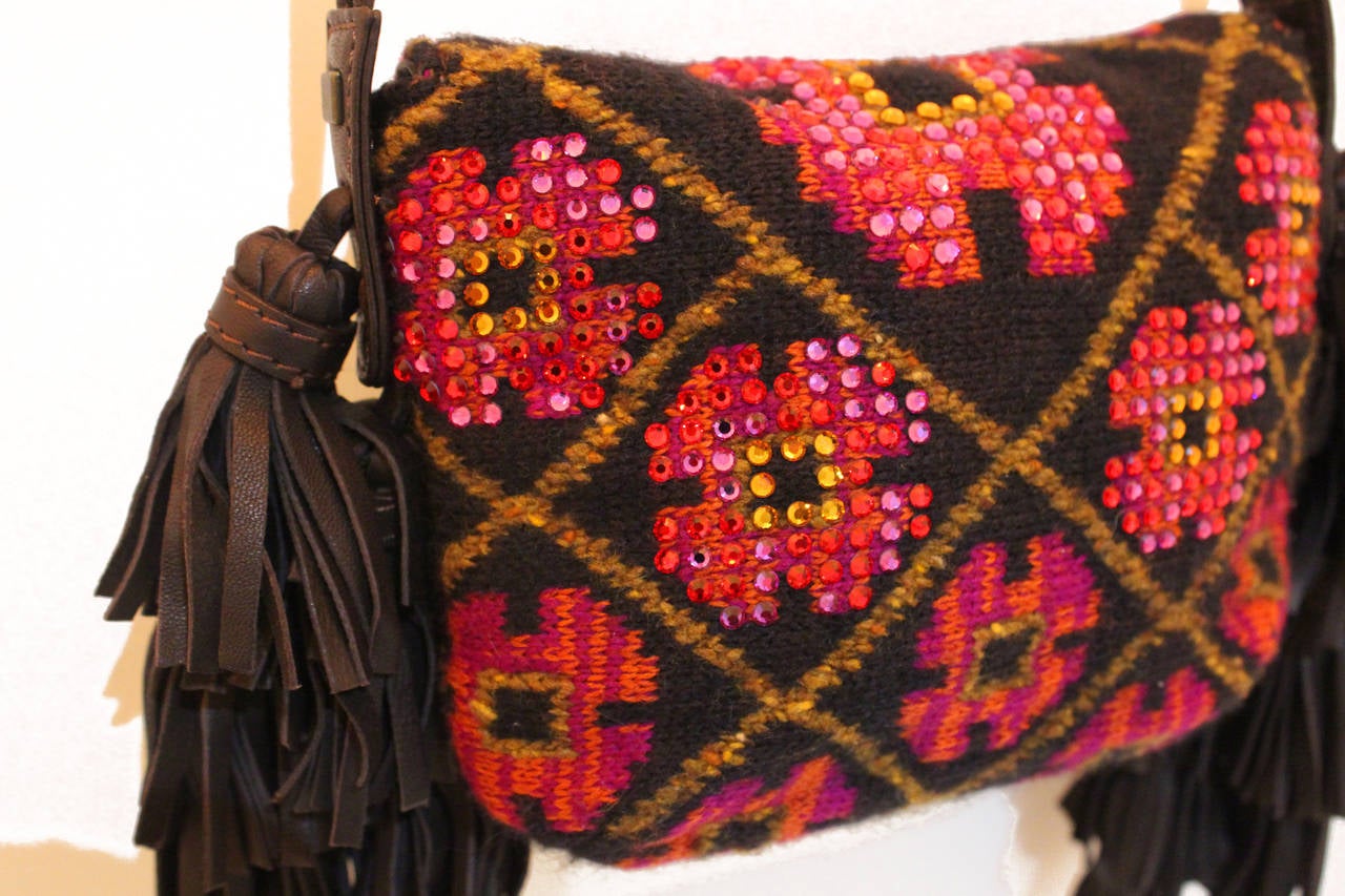 A brilliant and rare Sonia Rykiel knitted bag in a tapestry style with beaded embellishment and multiple brown leather tassels. The bag has a flap closure, long gold tone chain shoulder strap and interior key chain. 

Appears to have rarely been