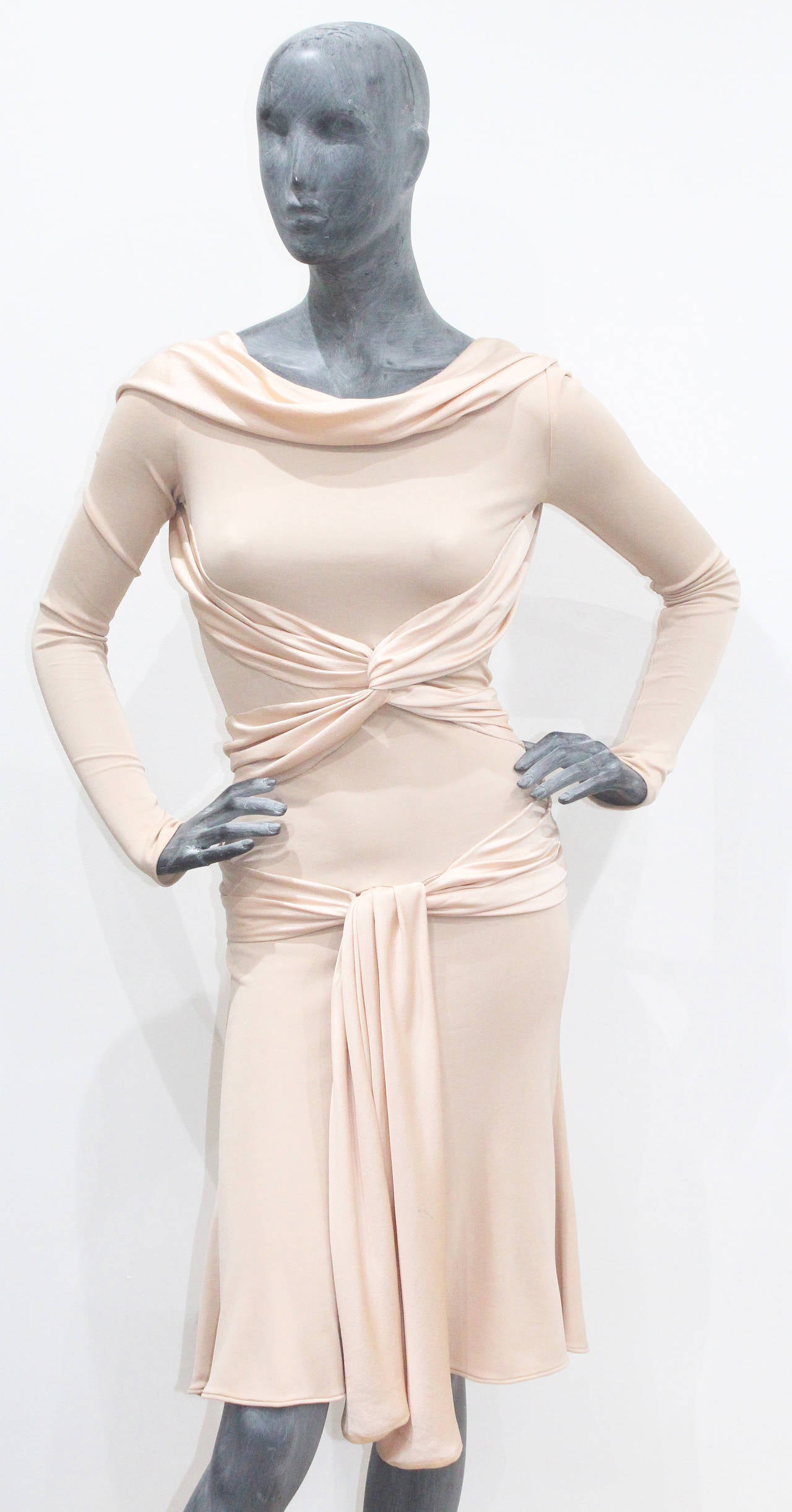 A fine and rare Alexander McQueen runway dress from the 'PANTHEON AS LECUM' Autumn/Winter 2004 collection. The dress is in a stretch nude/peach colour and has silk ties wrapping around the body. This dress definitely has a 1930s influence to it and