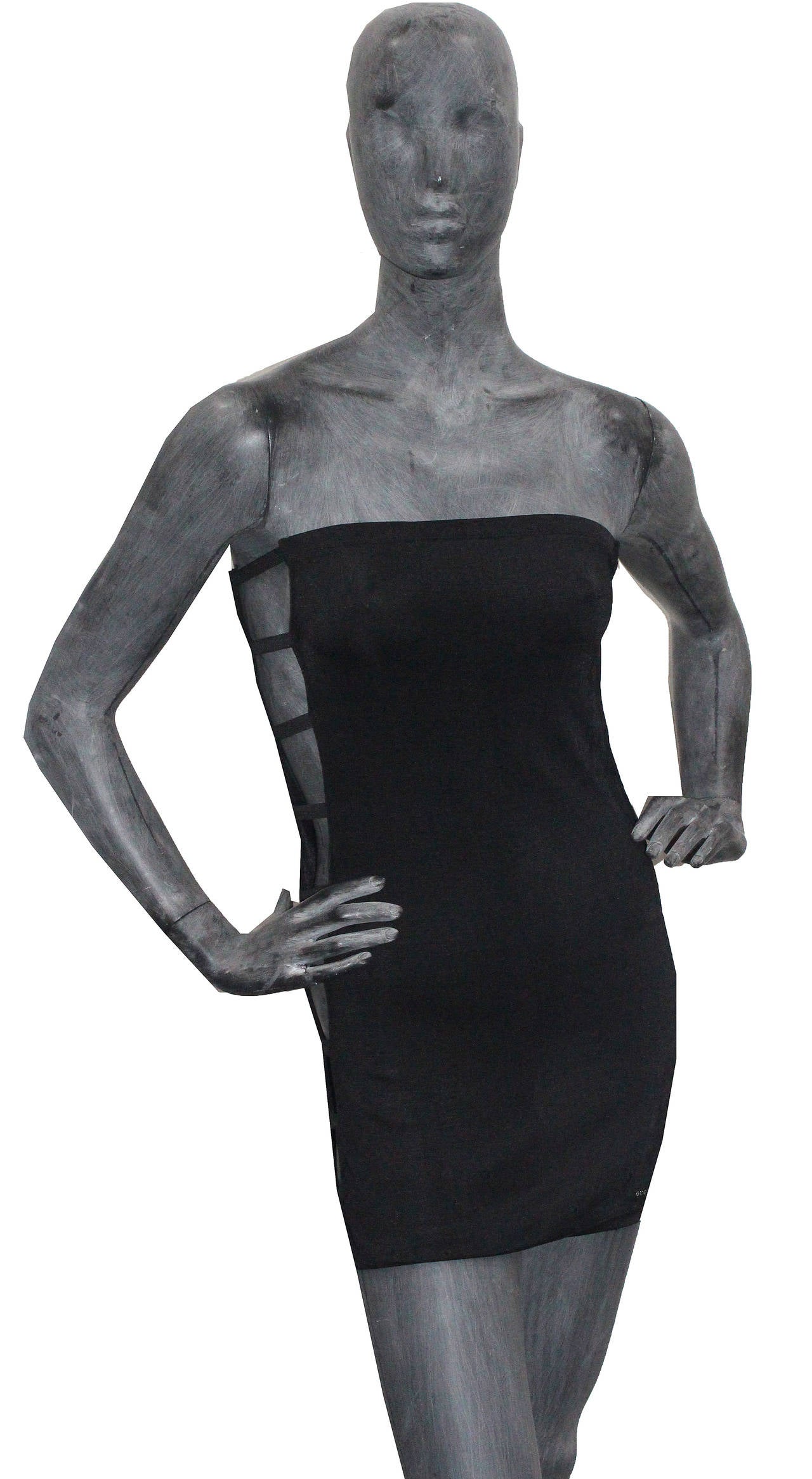 A mini dress by Gucci for Tom Ford made in 1999 for the Spring/Summer 2000 collection. The dress is in a black viscose with spandex and has bondage straps on either sides showing the skin of the wearer. 

Size - Medium