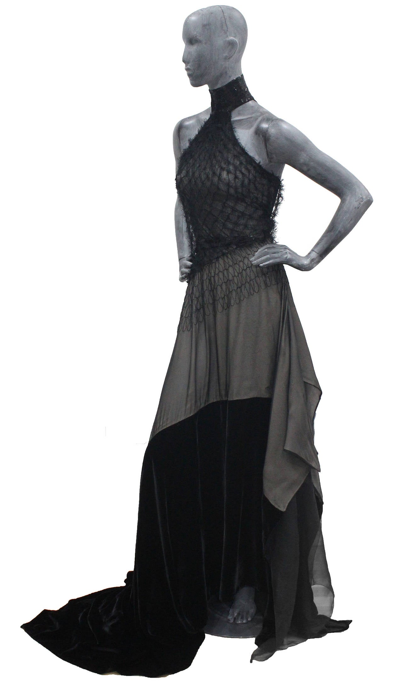 An outstanding evening gown by Gianfranco Ferre. The dress has a sequinned halter neck with a diagonal strap at the rear, netted bodice, open leg slit on the right and a long black velvet train. 

Size XS - SMALL / FR  34 - 36 / UK 6 - 8 / ITALIAN