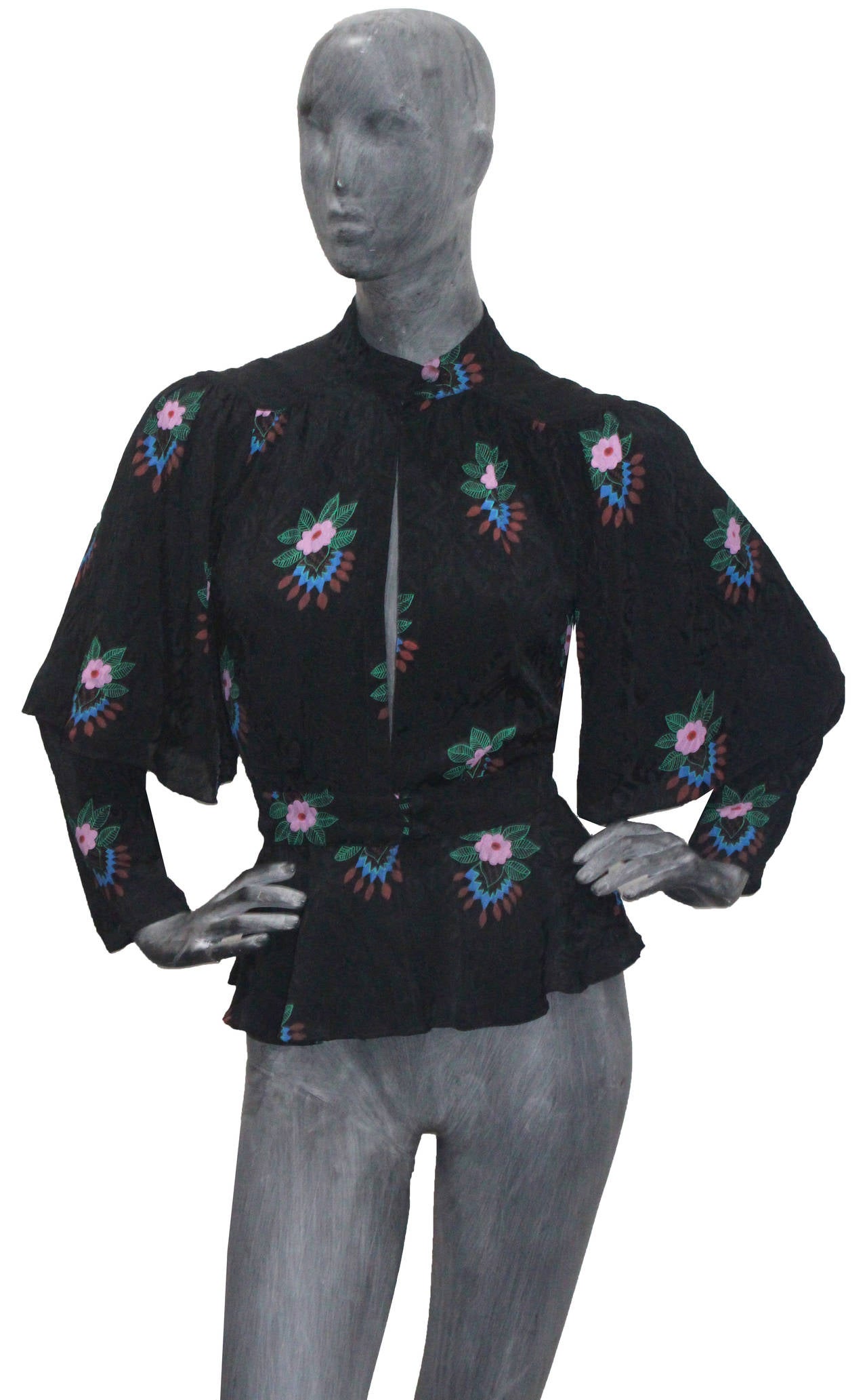 A very rare and extraordinary blouse by iconic fashion designer Ossie Clark. The peekaboo blouse features the 'Indian Bouquet' print by Celia Birtwell and has a plunge from buttoned neck to buttoned waist. The sleeves are fitted to the wrist and