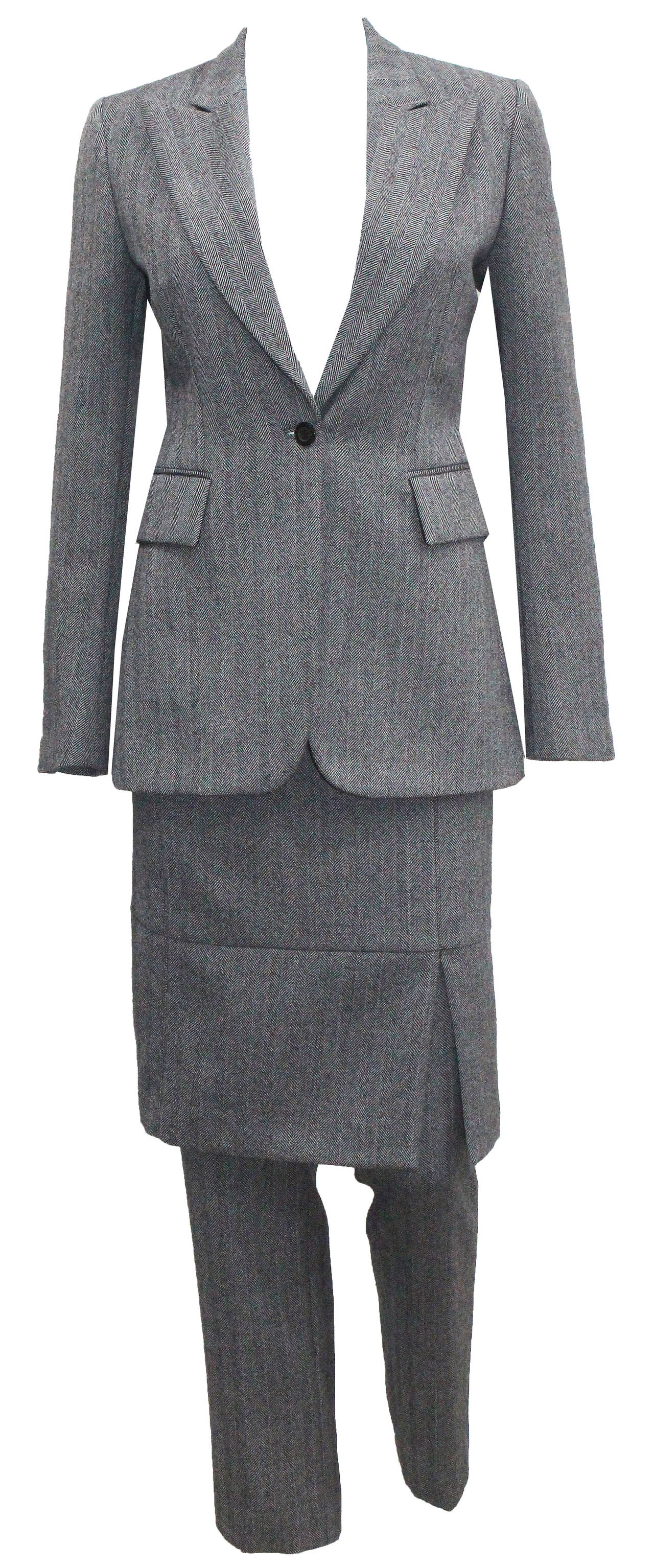 A unworn tweed 3 piece suit by Gucci, designed by Tom Ford for the Autumn/Winter 2000 runway collection. The suit features a fitted blazer, cigarette tweed pants with calfskin leather details and fitted pencil skirt also with leather details. 100%