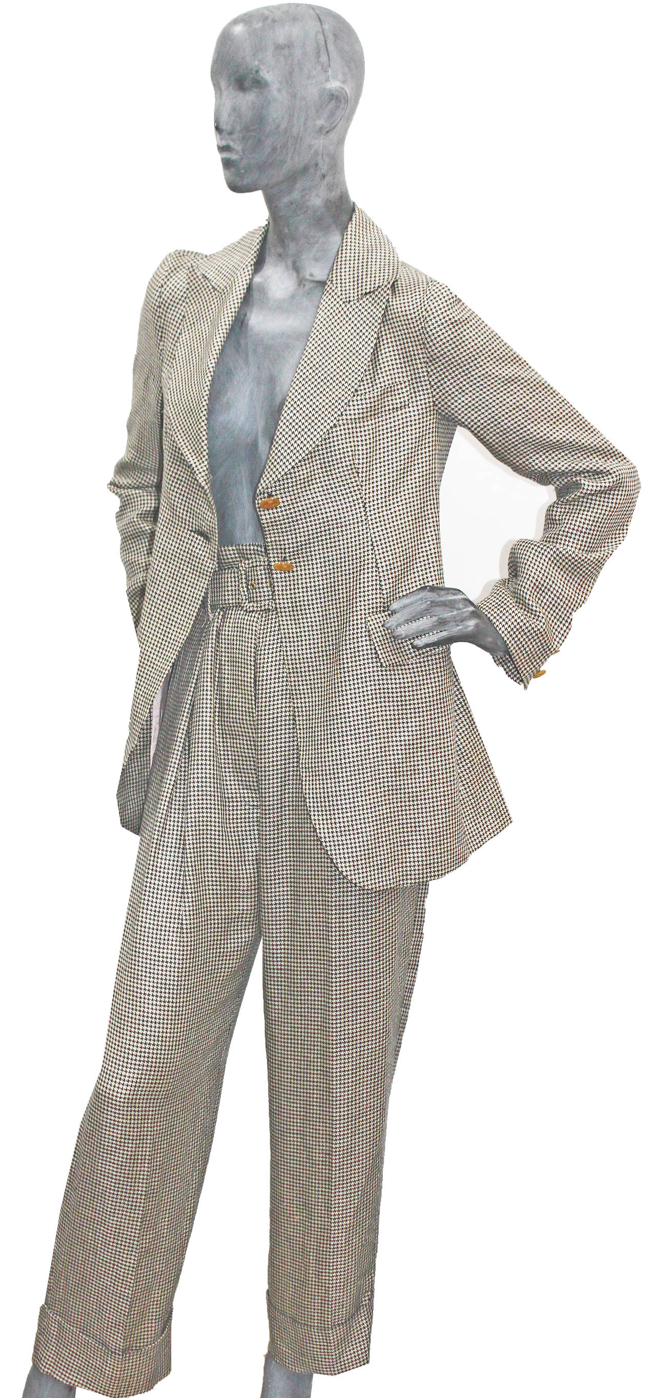 A Vivienne Westwood pant suit from the 1990s. The suit includes belted high waisted pants with a low crotch and a two button tailored blazer.

UK 12