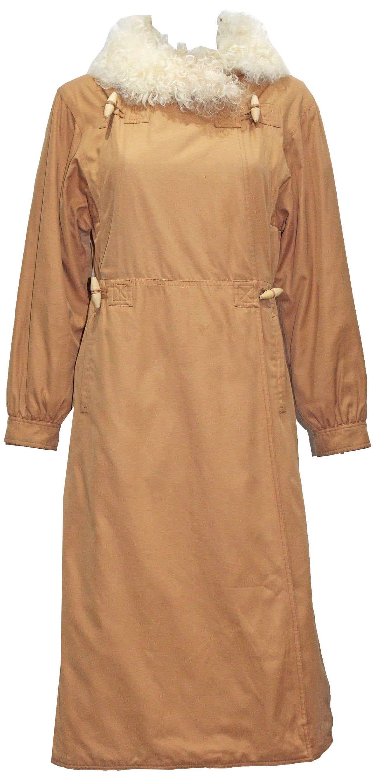 A fine and rare cotton tan coat by Courreges from the 1960s. The coat has a Mongolian lamb collar, wooden toggle buttons and quilted lining.