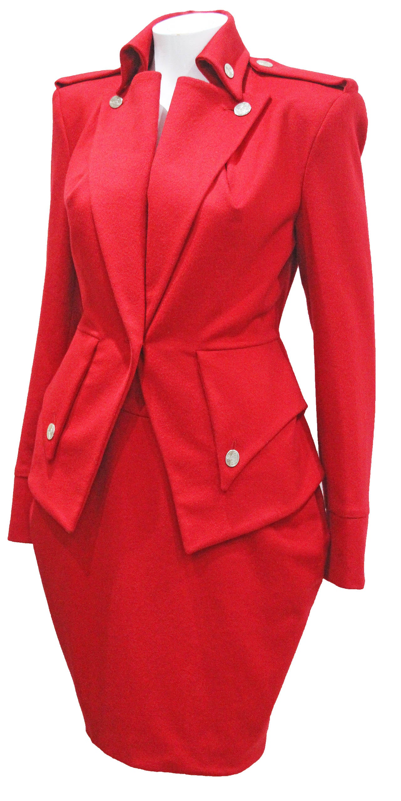 A fine and rare Vivienne Westwood tailored 2 piece skirt suit. The ensemble features a high waisted tulip skirt and a military inspired jacket with an hour glass cut and unique pleated to insinuate the waist. 

Condition: New with tags / Mint