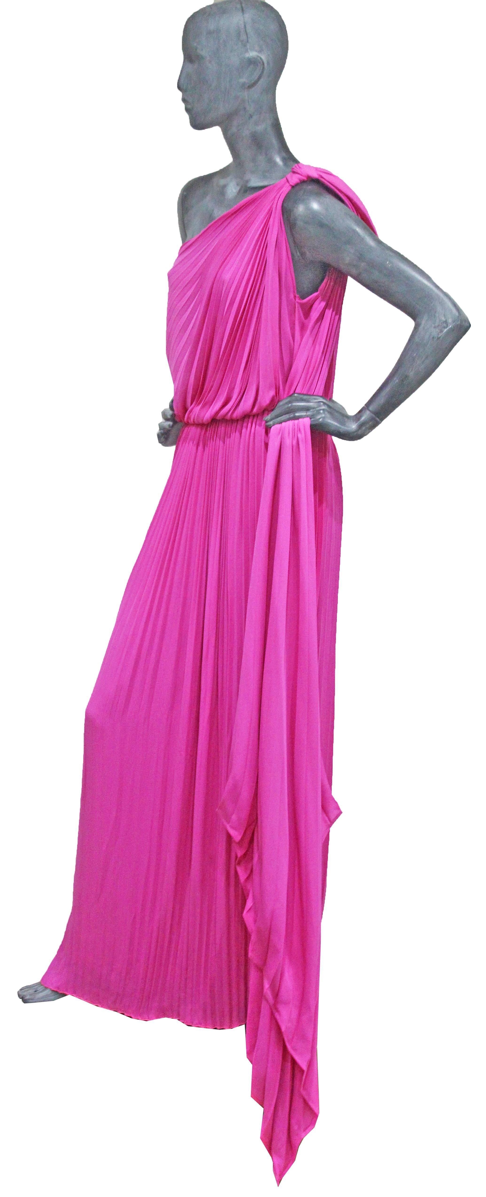 An exceptional Grecian inspired asymmetric hot pink pleated evening dress. The dress has a large bow which hangs off the shoulder with a long pleated train.  

100% Silk

Size
Shoulder to shoulder - 15