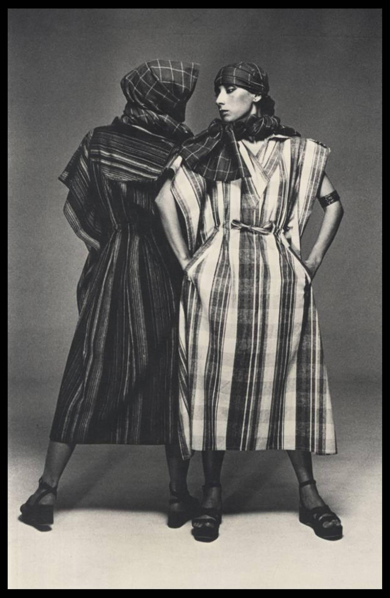 A knitted 2 ensemble by Issey Miyake from 1976. 

Ensemble includes the following:

1 striped knitted open caftan with extra long ribbed knit hooded scarf and 2 side open pockets

1 striped knitted long sleeve draped dress with 2 side open