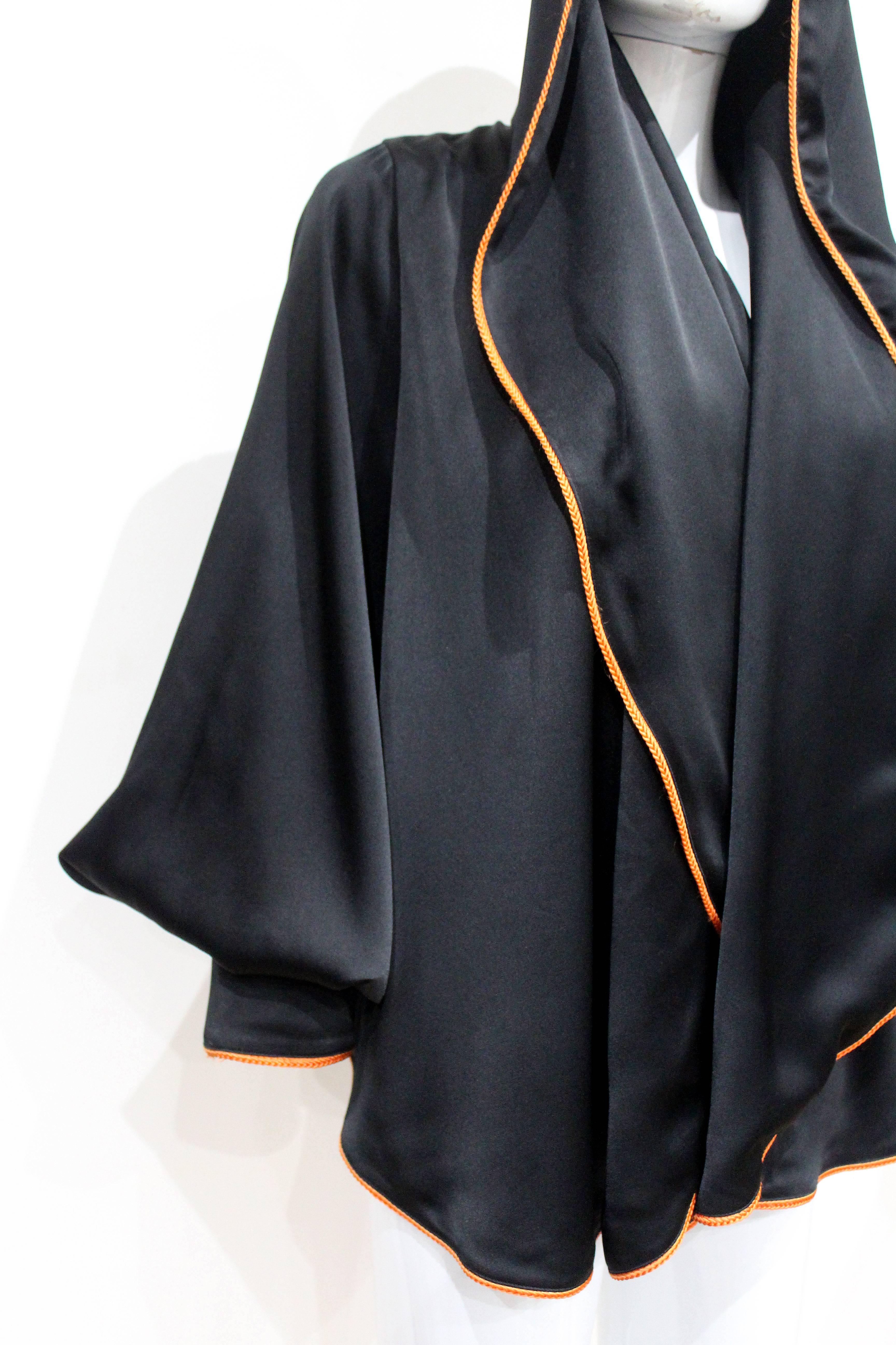 A stylish Vivienne Westwood black evening jacket with orange braided trim. The jacket can be styled with a hood and has billowing poet sleeves. No closure. One Size:

Excellent Condition