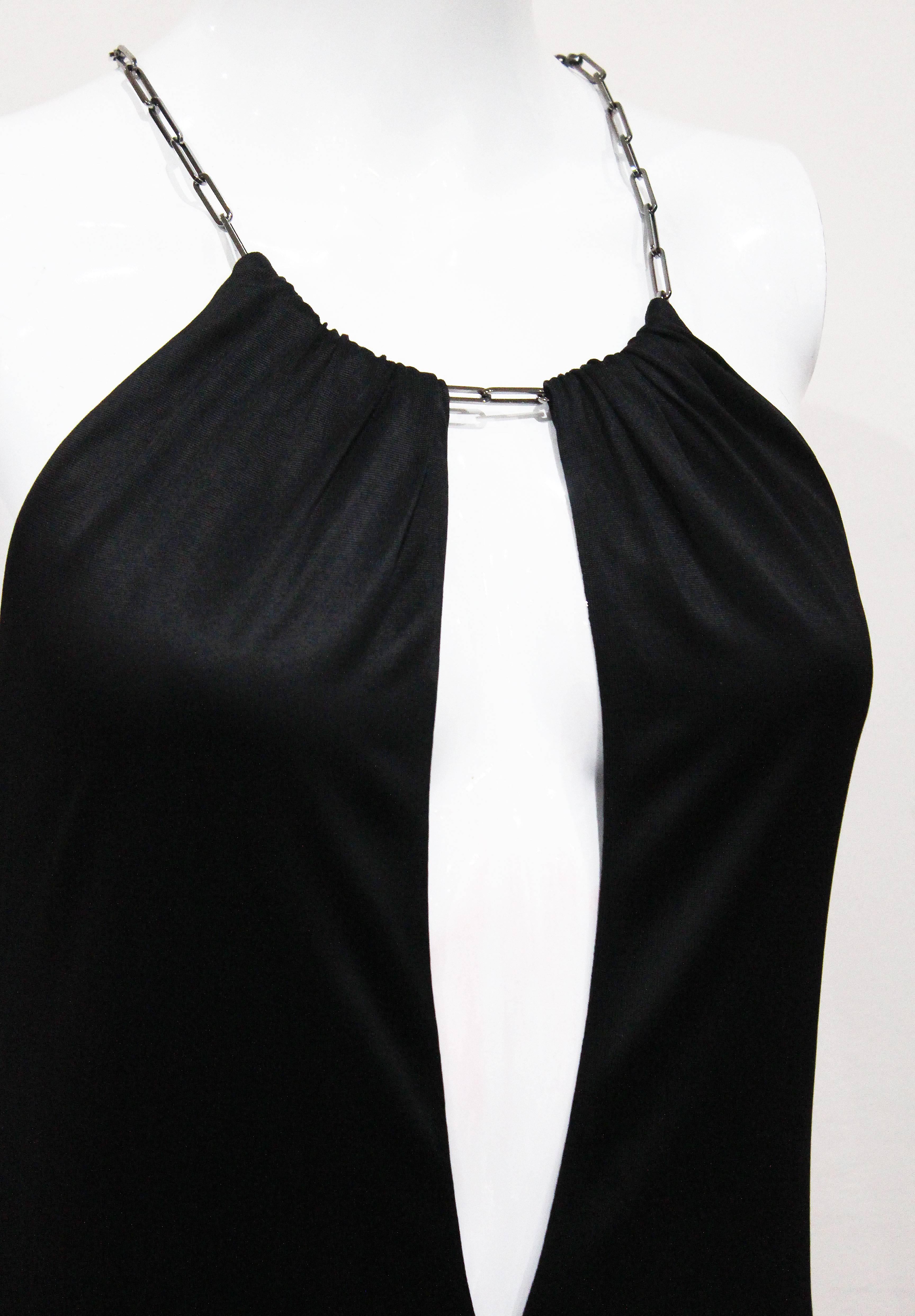 A Tom Ford for Gucci black jersey dress from the Spring/Summer 2000 collection. The dress hangs off a metal silver chain necklace and has a deep plunge at the front. 

Italian 38 / French 34 / UK 6 / XS