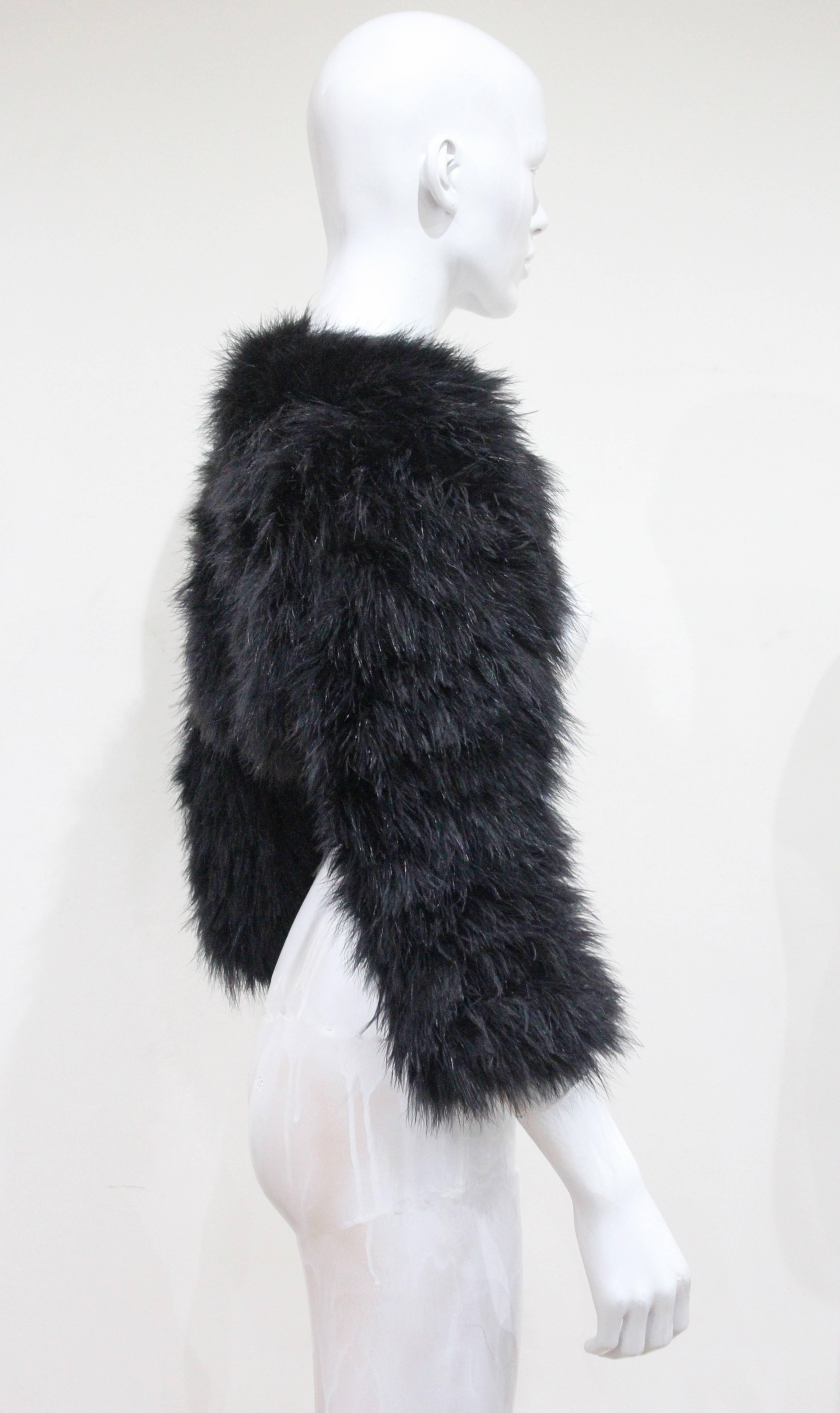 An Alexander McQueen black marabou fur bolero jacket from the year 2005. The jacket leaves the front bear and covers the back and arms. 

Italian 40 - French 36 - UK 8 - Small