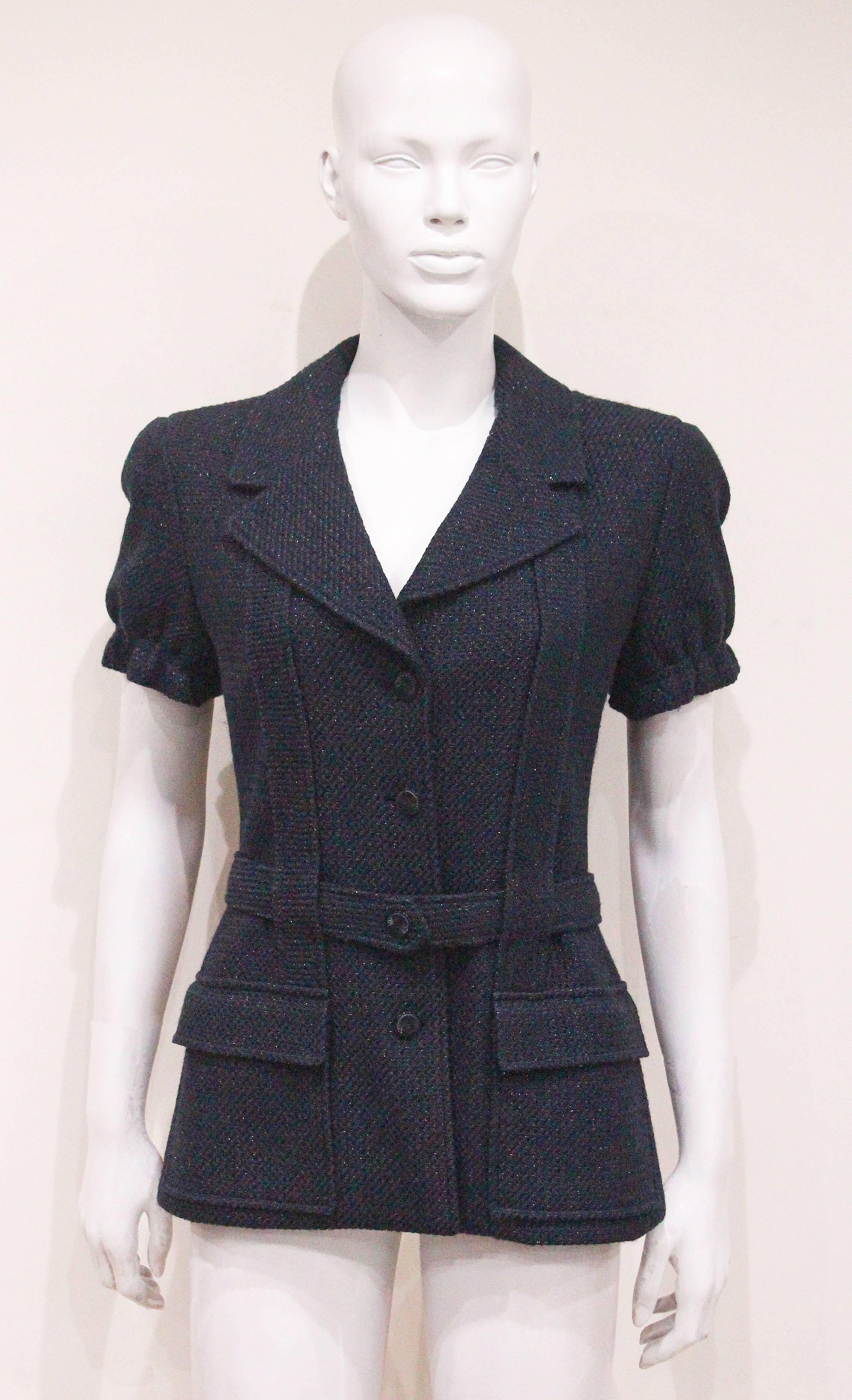 A Chanel tweed jacket from the Spring/Summer 2001 season. The jacket has short puff sleeves with elasticated cuffs, matching tweed belt, two front flap pockets, silk logo lining and interior metal chain hem. 

Fr 40 