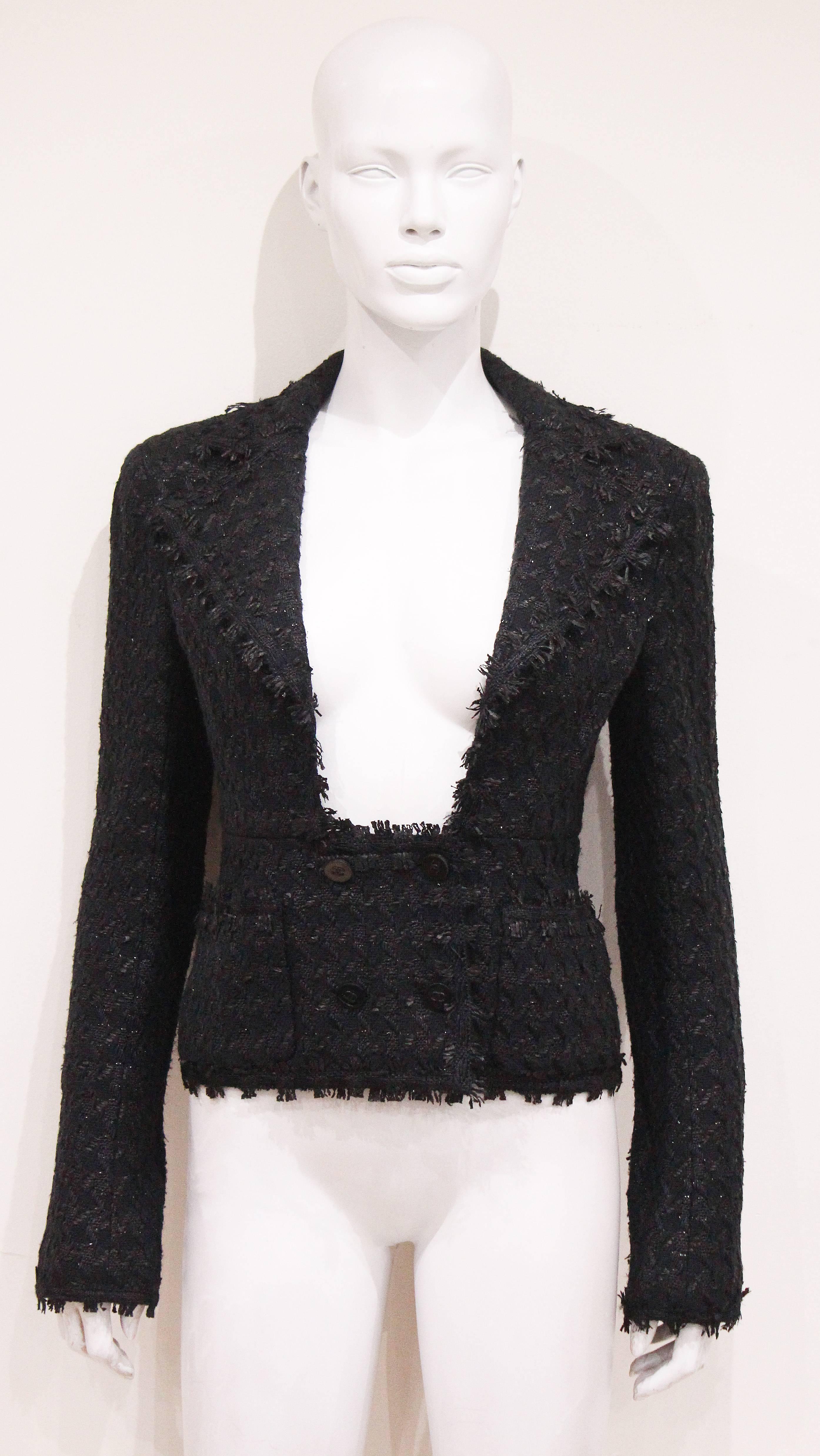 A black fantasy tweed low plunge double breasted jacket with silk lining and interior chain on hem. Made in 2005. 

The jacket is in excellent condition, the only flaw is a cut on the label. 

Fr 38 
