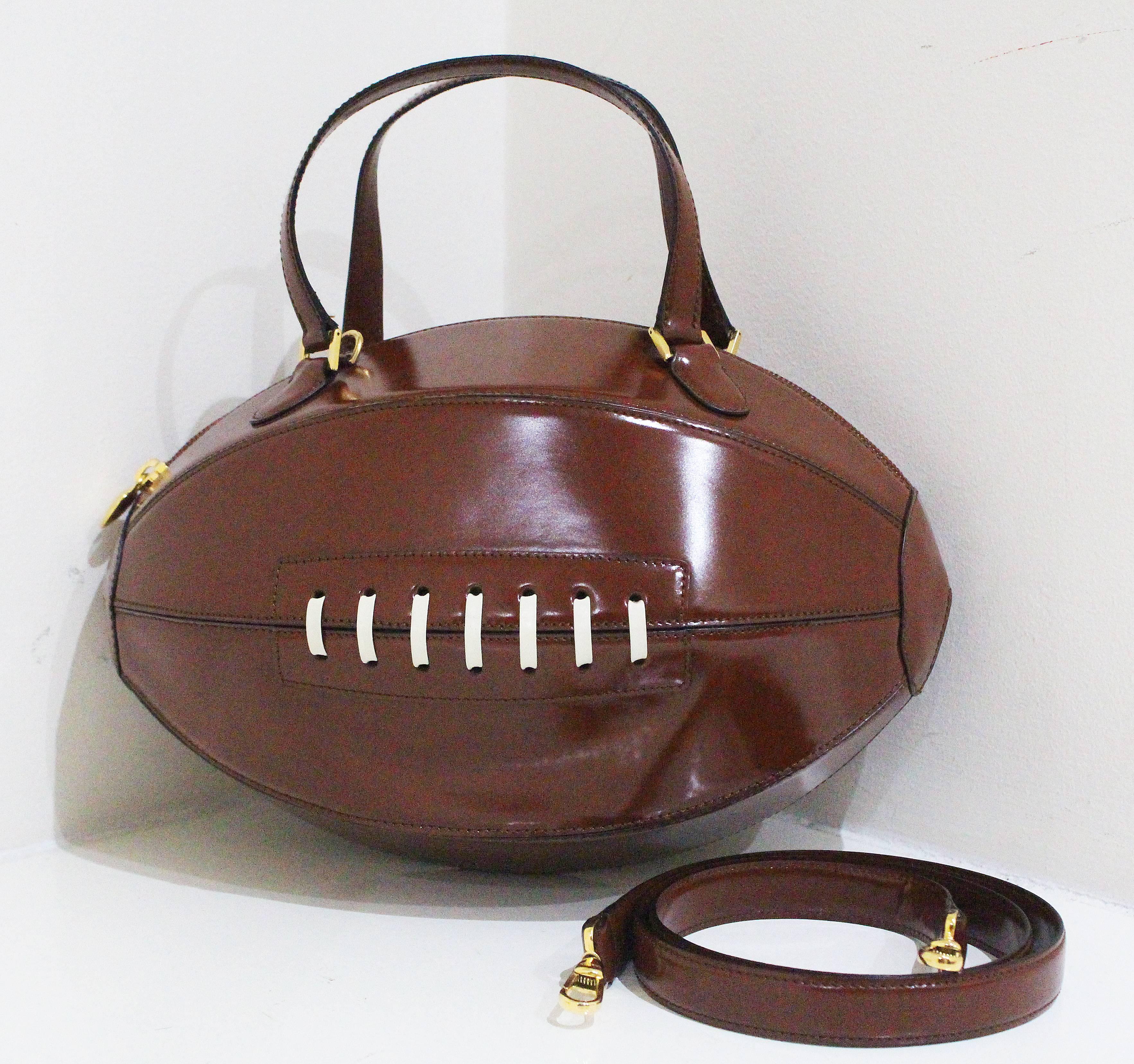 A rare and collectible Moschino bag in the of an American football from the year 2001. The bag features gold heart zipper, gold Moschino stamp at rear, original dust bag and detachable shoulder strap. 

Brand new / unworn