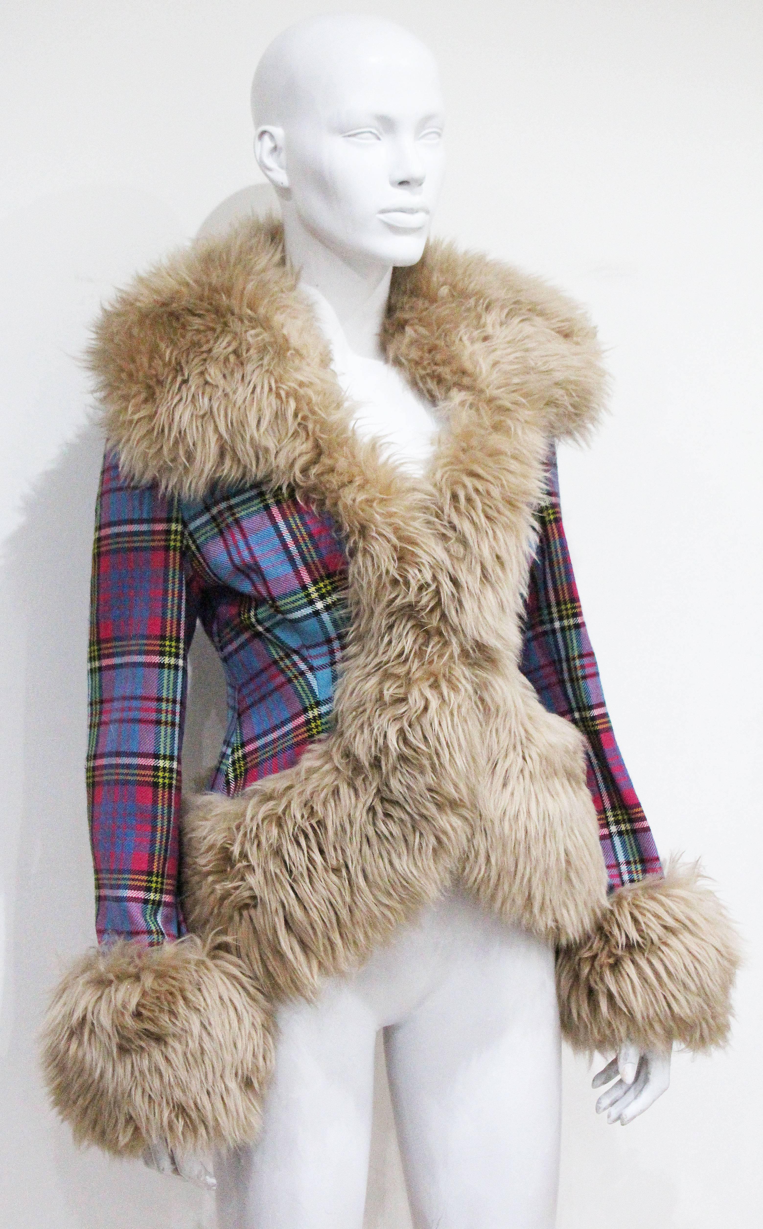 An Iconic Vivienne Westwood sheepskin jacket from the Autumn/Winter 1993 collection. The jacket features a wool tartan throughout and oversized sheepskin collar and cuffs. 

UK 12 - Medium 