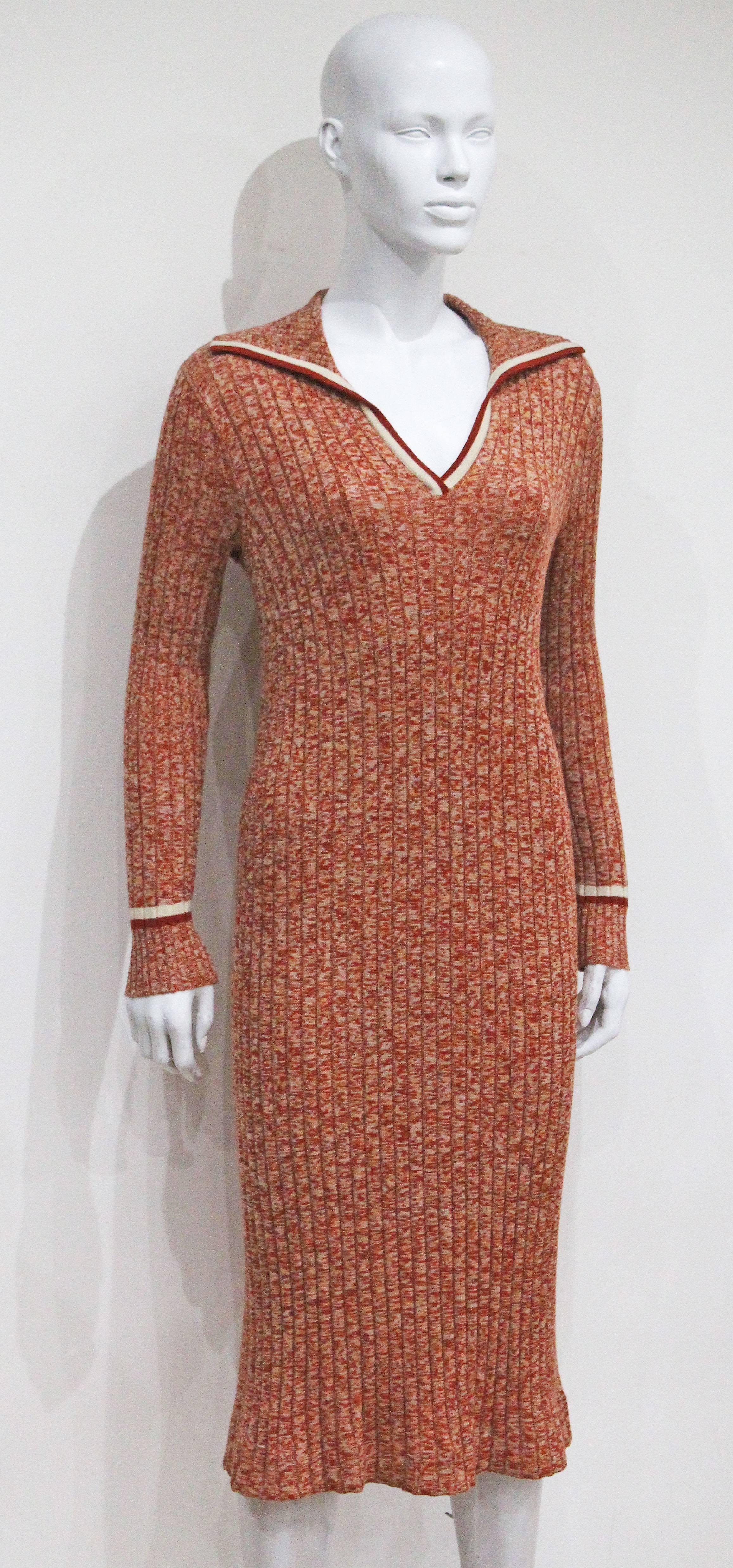 A rib knit dress by Céline from the 1970s. The dress is in a speckled orange tone rib knit wool and features a wing collar and striped bands around the cuff and collar. 

S - M