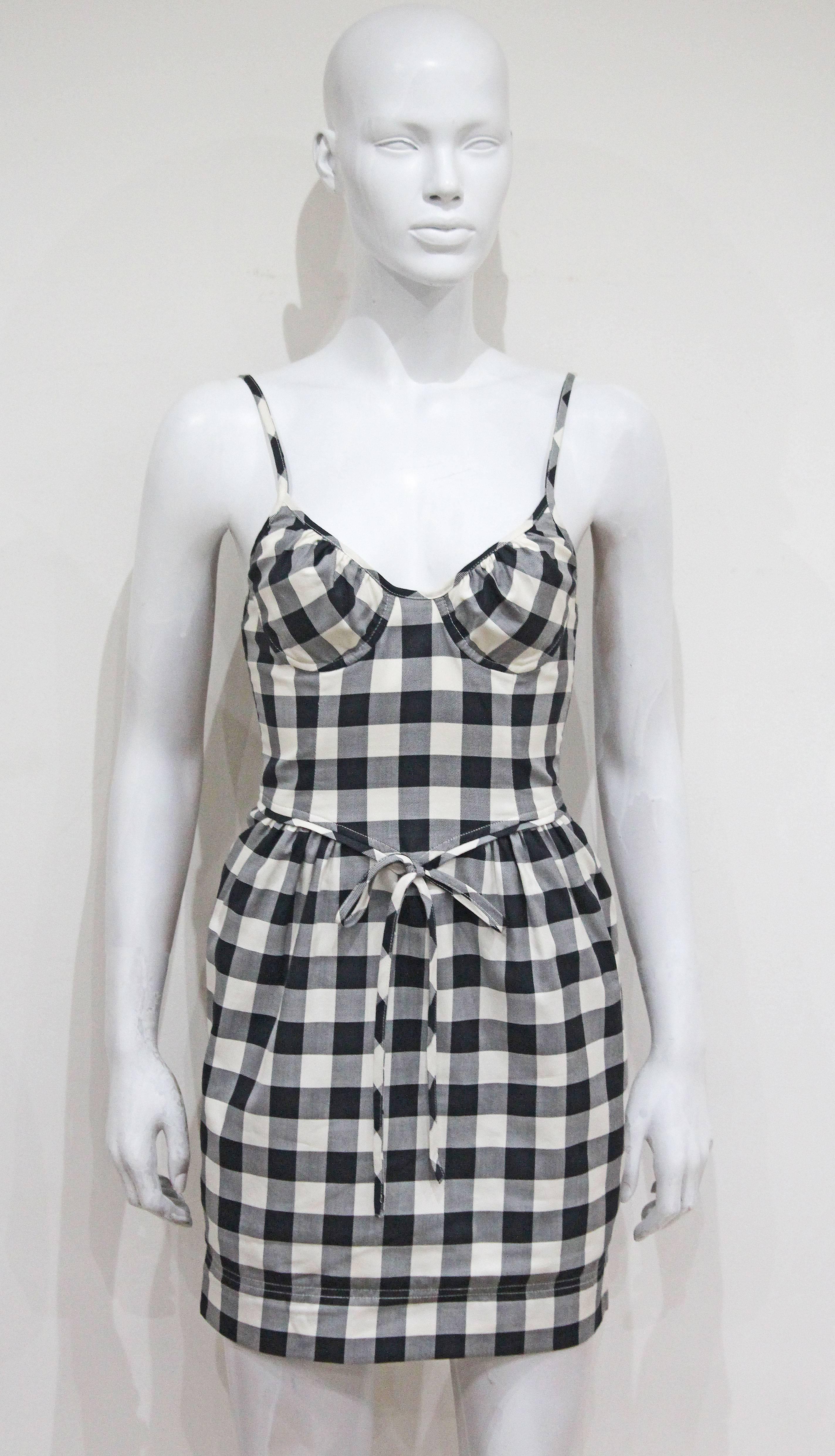 A Moschino gingham mini dress from the 1990s. The dress features spaghetti straps, bra like bust and puff skirt. 

It 40 - Fr 36 - UK  8