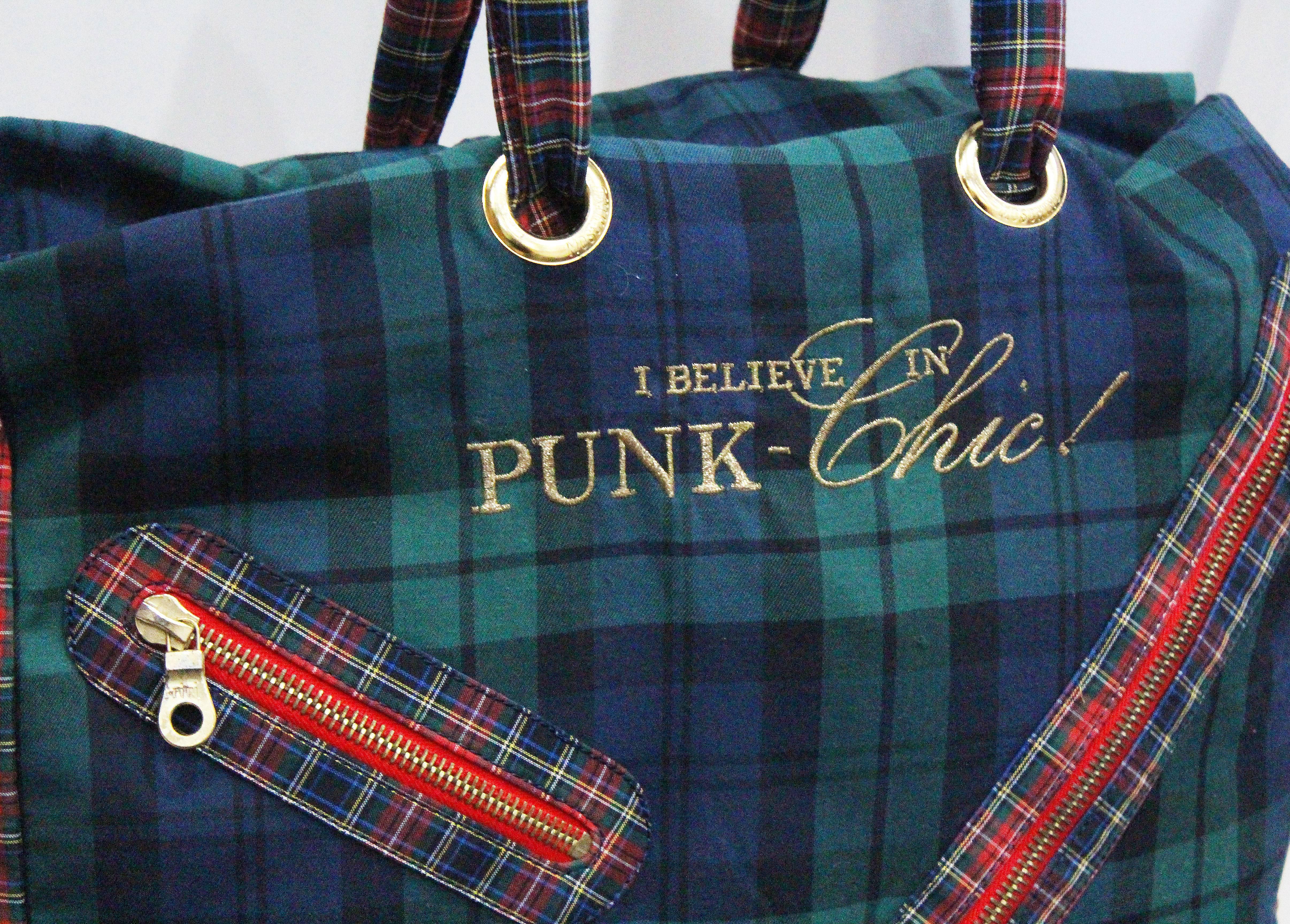 A Moschino large tote bag and matching purse from the early 1990s. The bag is in a mix match tartan print and features two top handles, large safety-pin zipper, and a gold embroidered 'I BELIEVE IN PUNK CHIC!' motif. 


