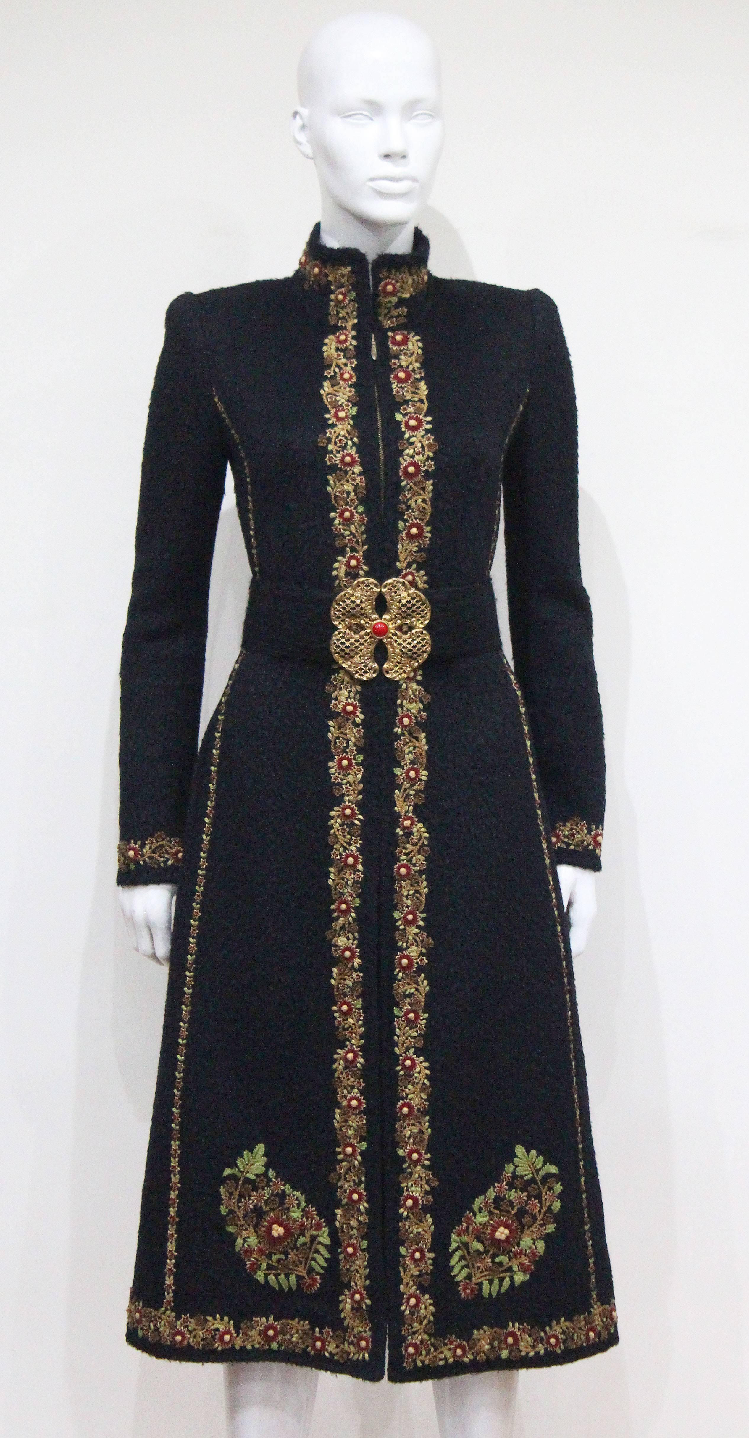 An Oscar de la Renta woollen coat from the 1990s. The coat features intricate hand stitched embroidery throughout and matching belt with metal clasp. 

Fr 38  