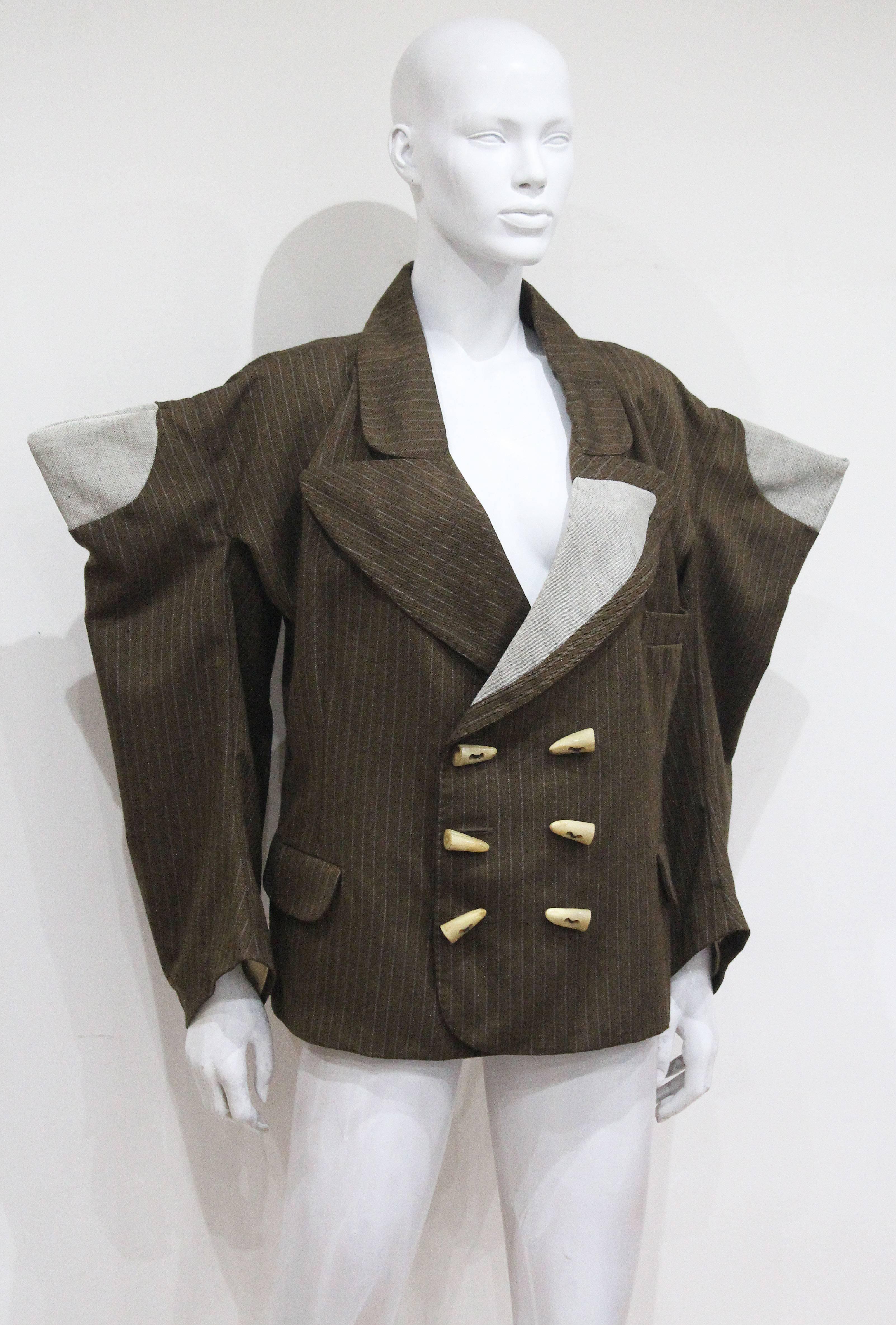 World's End by Vivienne Westwood and Malcolm Mclaren oversized striped brown herring-bone double breasted jacket with angular collar, large celluloid antler style buttons, massive angular shoulders inset with grey cotton roundels. From the 'Witches'
