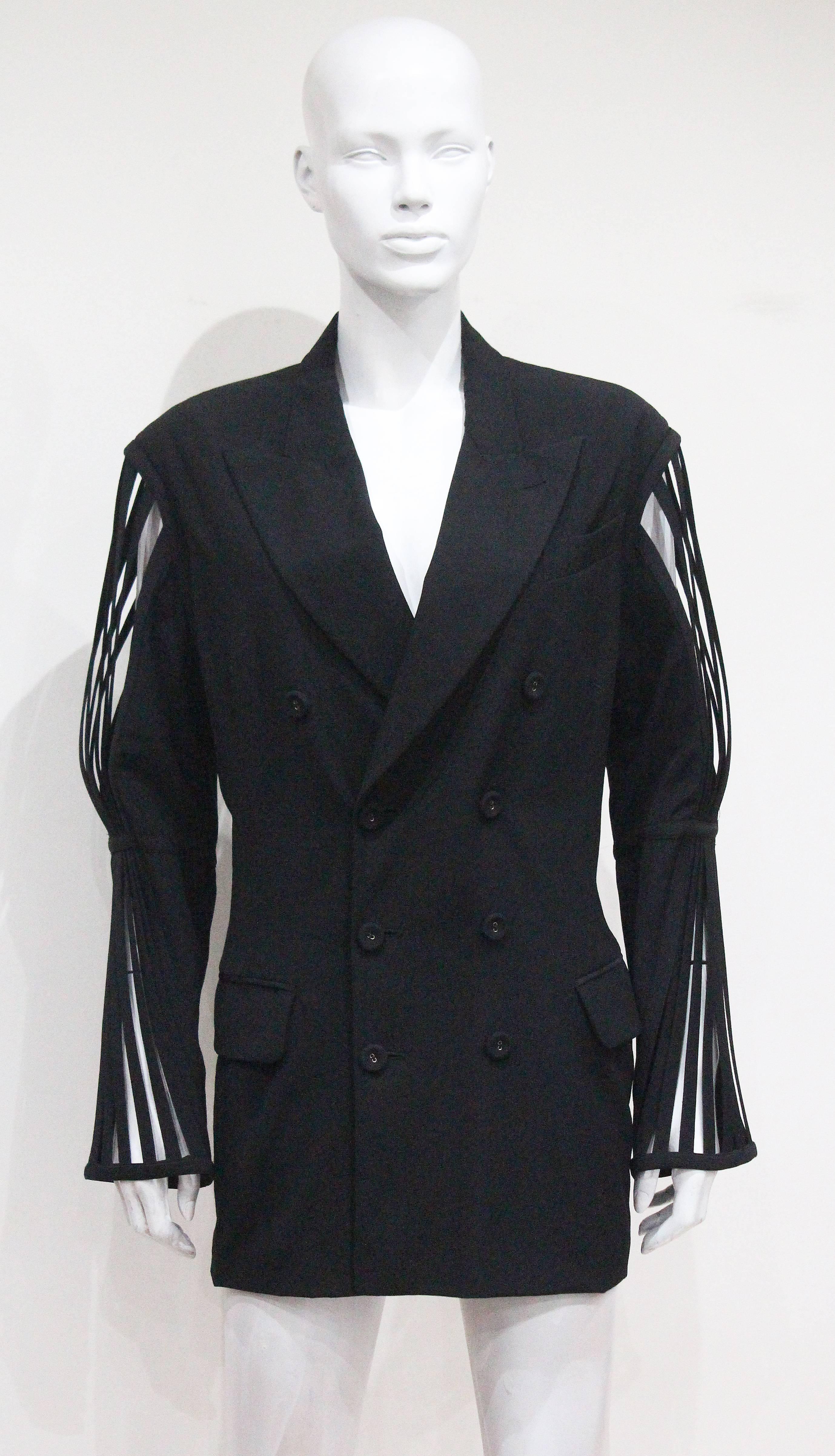Fine and rare Jean Paul Gaultier double breasted black woollen blazer jacket, circa 1989. The blazer jacket has extraordinary caged boned sleeves. The beauty about this piece is that we believe it could be worn by a woman styled as a mini dress or