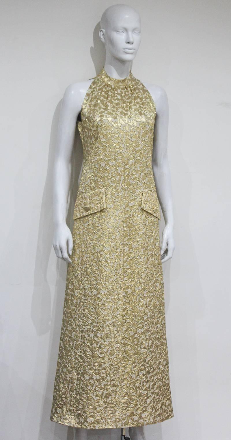 An exquisite 1968 evening dress by the legendary French fashion house Jean Patou. The dress is a classic late 60s a-line finishing just above the ankles, it features two front imitation pockets for decorative purpose, ivory silk lining, a side metal