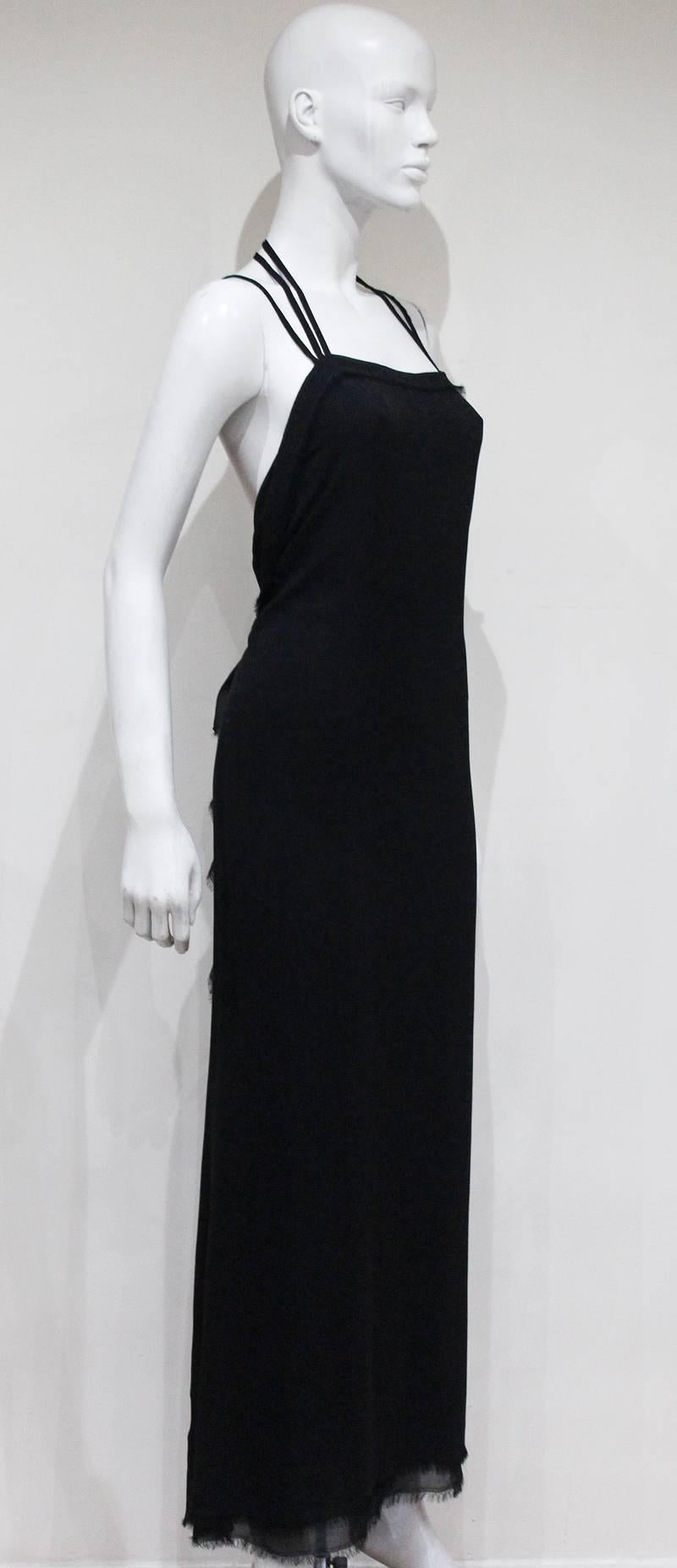 A Yves Saint Laurent silk chiffon black evening dress from the Autumn/Winter 2001 season, designed by Tom Ford. The dress features three halter neck straps and intentional frayed edges throughout. The seam closes in the centre at the rear of the