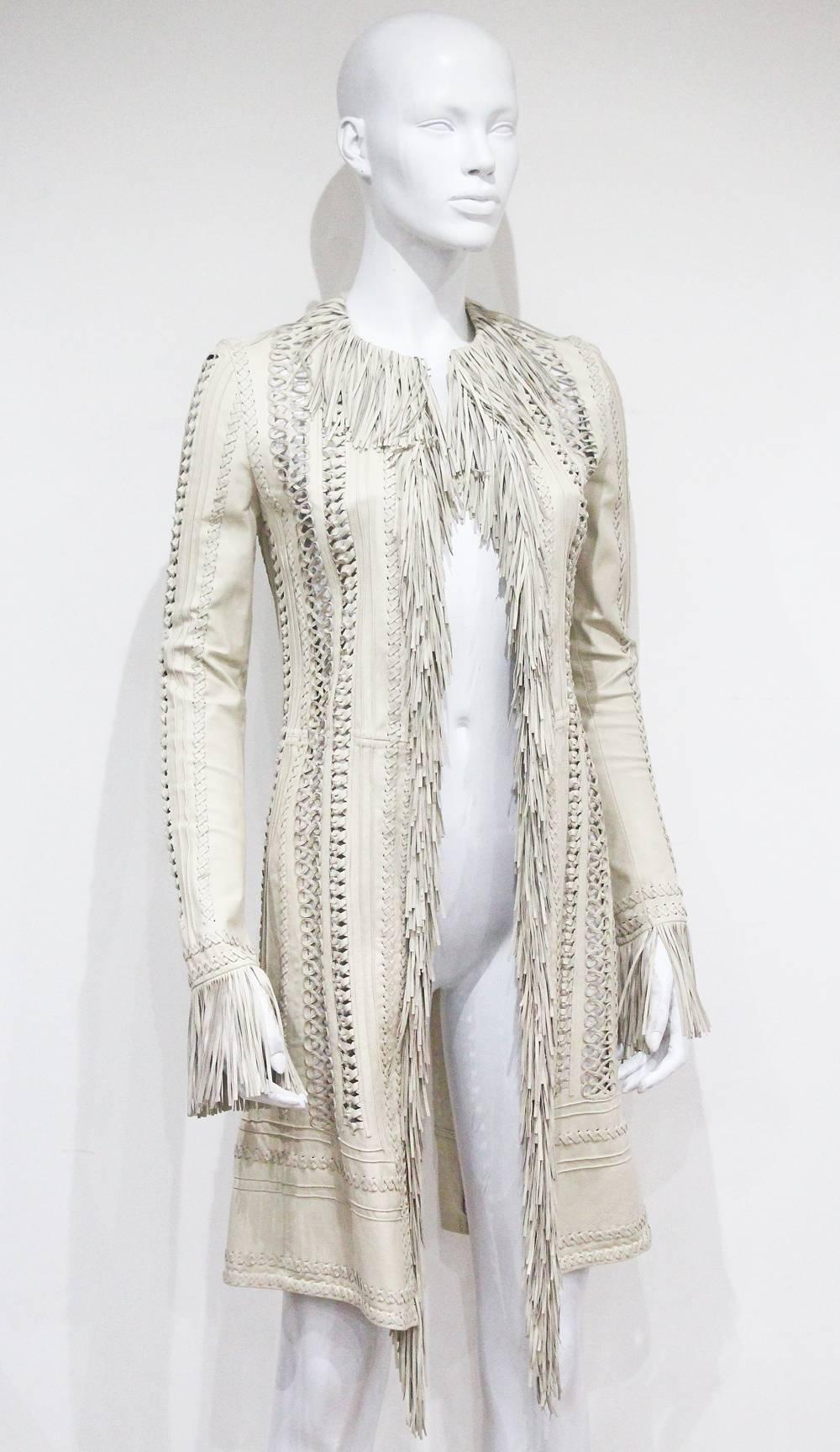 A Gianni Versace leather jacket from the spring/summer 2002 collection, designed by Donatella Versace. The jacket features intricate woven leather, long leather fringing and metal hook and eye closures. 

It 38 - Fr 34 - S  
