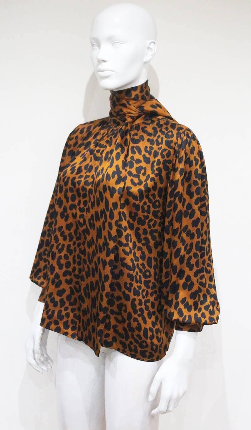 Yves Saint Laurent 1970s silk blouse in a leopard print with bishop sleeves and high neck attached scarf. 

Fr 38 