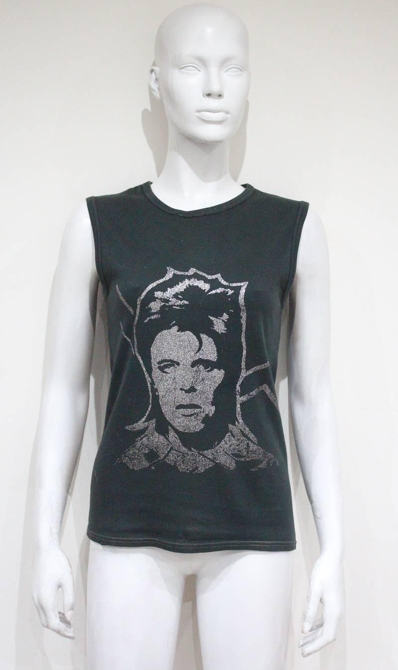 An original 1970s vest from the David Bowie Ziggy Stardust era. The vest is of a grey cotton and features a metallic silver screen print of Ziggy. 

Designer unkown