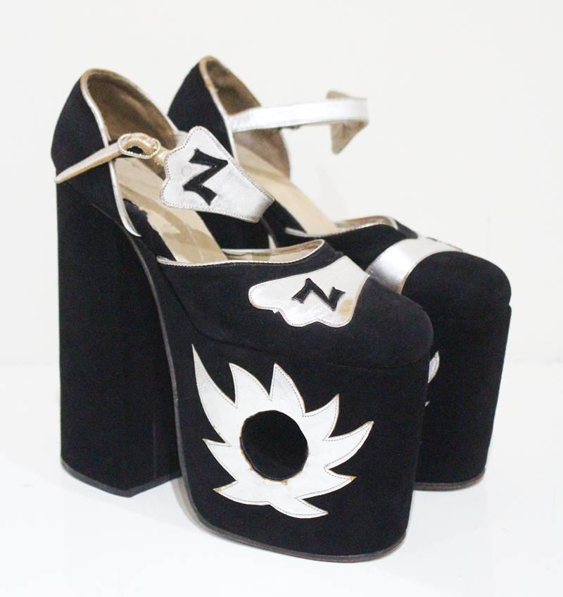 A pair of original 1970s super high platforms with a seven inch heel in black suede and silver leather. The platforms feature a circular cut out and the letter 'Z' for Ziggy on the toe and the strap. 

Size not stated approx. 9 inches long 