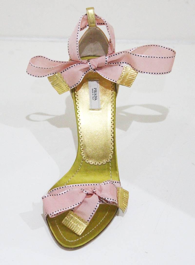 A pair of Prada evening sandals with a red velvet heel, gold leather sole and pink satin bow fastening. 

Sz 38 

Excellent condition, never worn and comes with original Prada dust bags
