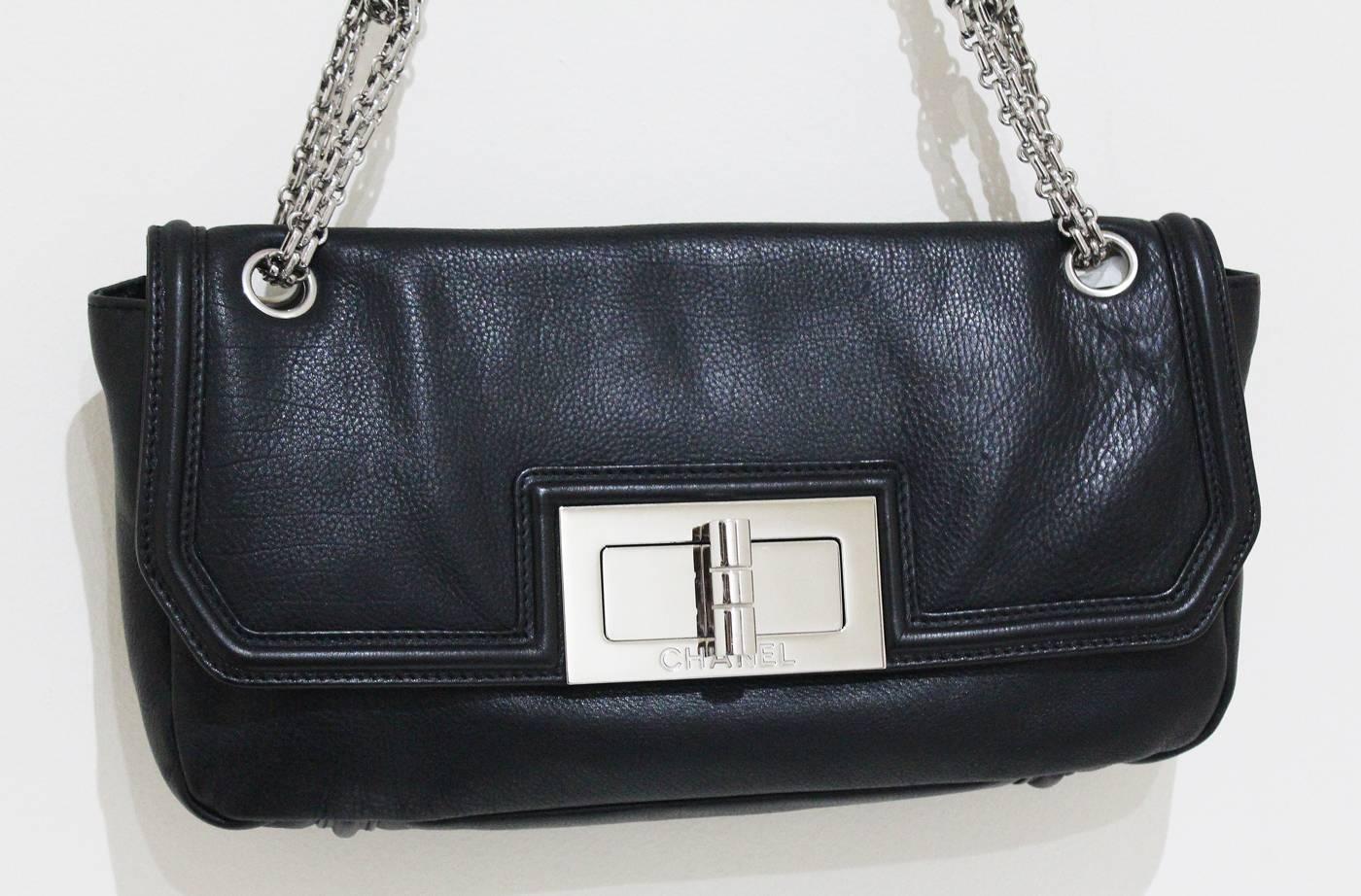 The Chanel 'Sac Baguette' bag in black grained lambskin leather with silver palladium hard wear. The flap bag features a pivot-turn, oversized, signed silver clasp, grey satin lining and double-link chain shoulder strap. 

Excellent Condition -