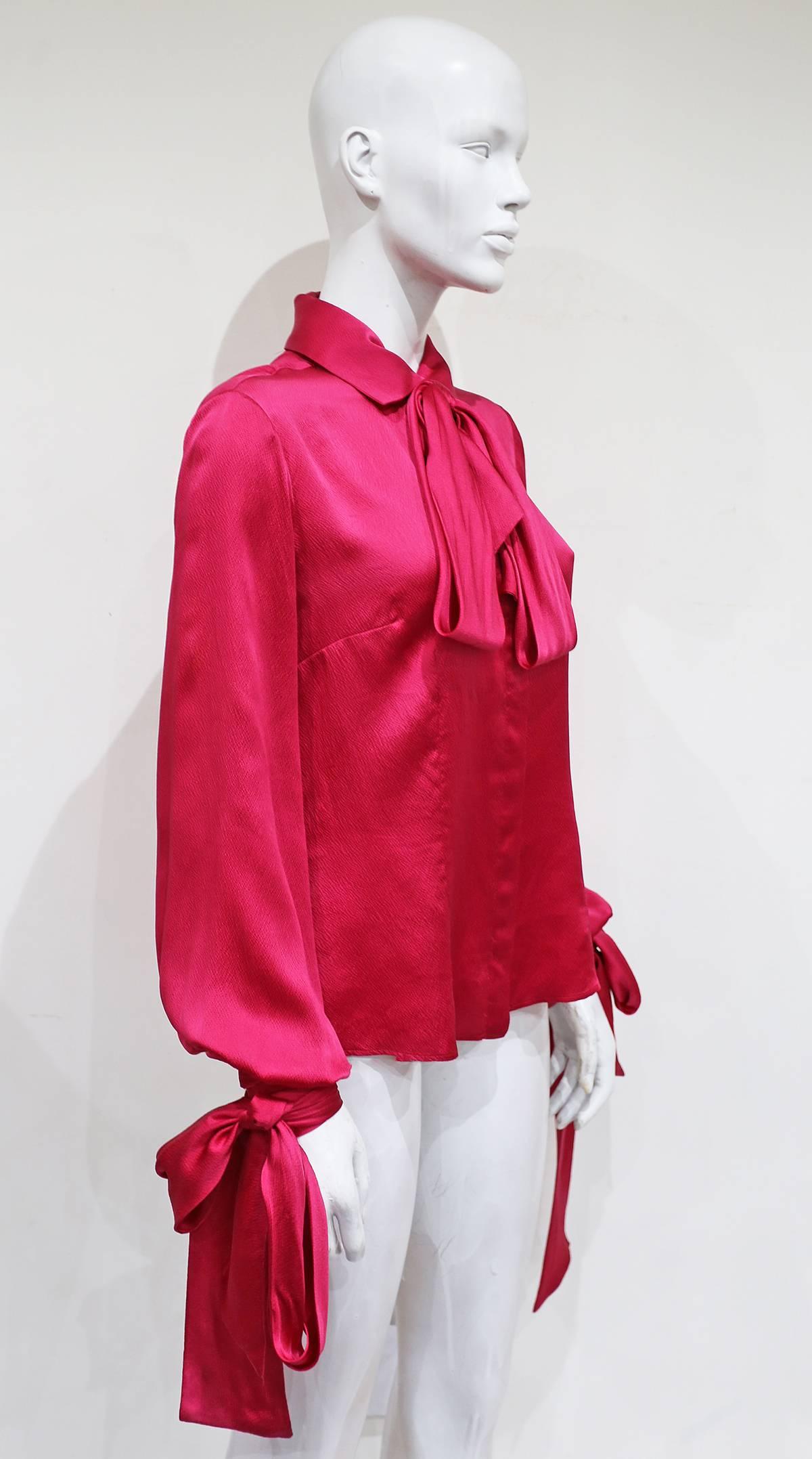 Alexander McQueen evening blouse in fuchsia pink silk with bishop sleeves and three extra long ties on the collar and cuffs. 

It 42 - Fr 38