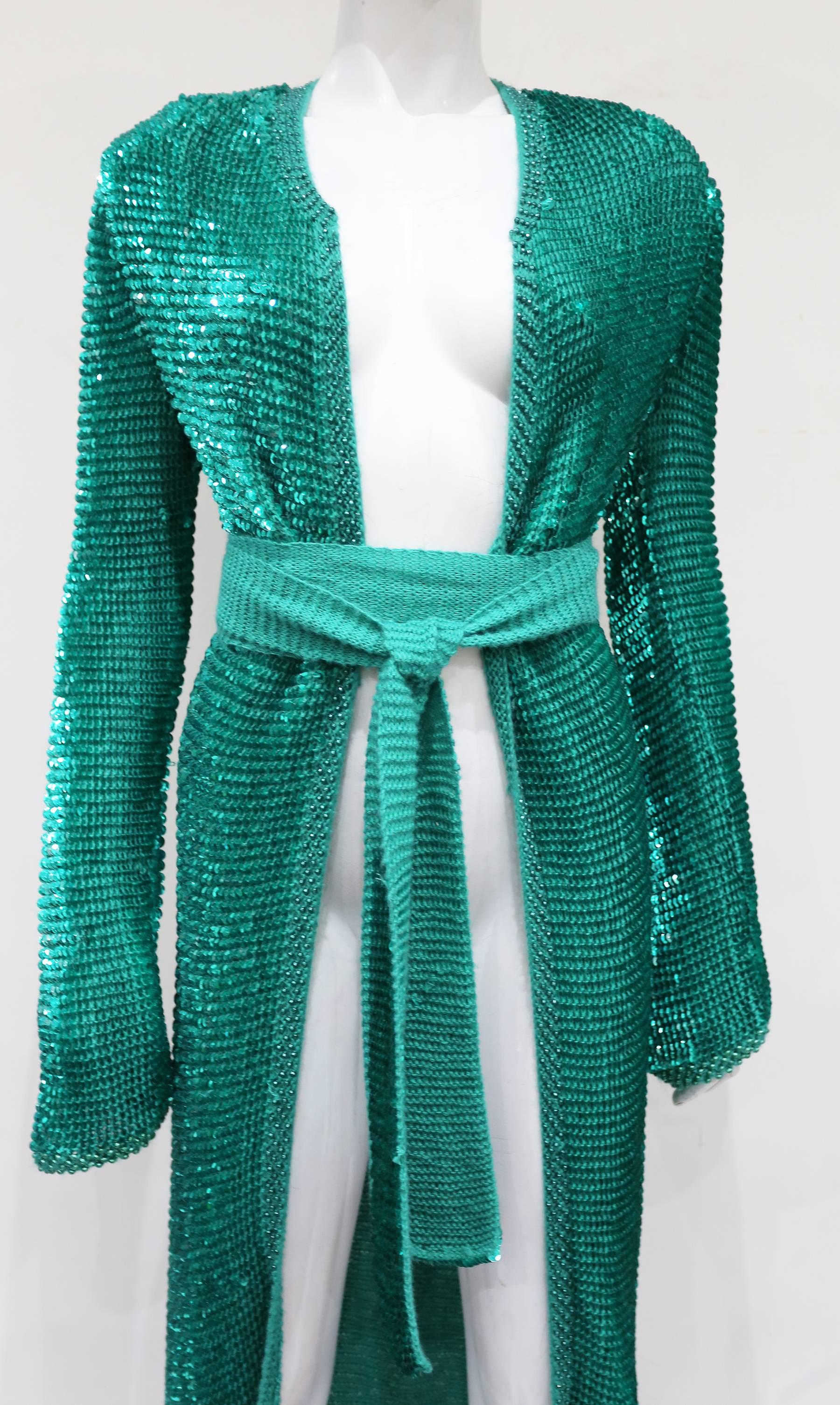Evening knitted cardigan/dress coat by Dolce & Gabbana covered in turquoise sequins. Worn open and fastens with matching knitted waist belt. 

Small 