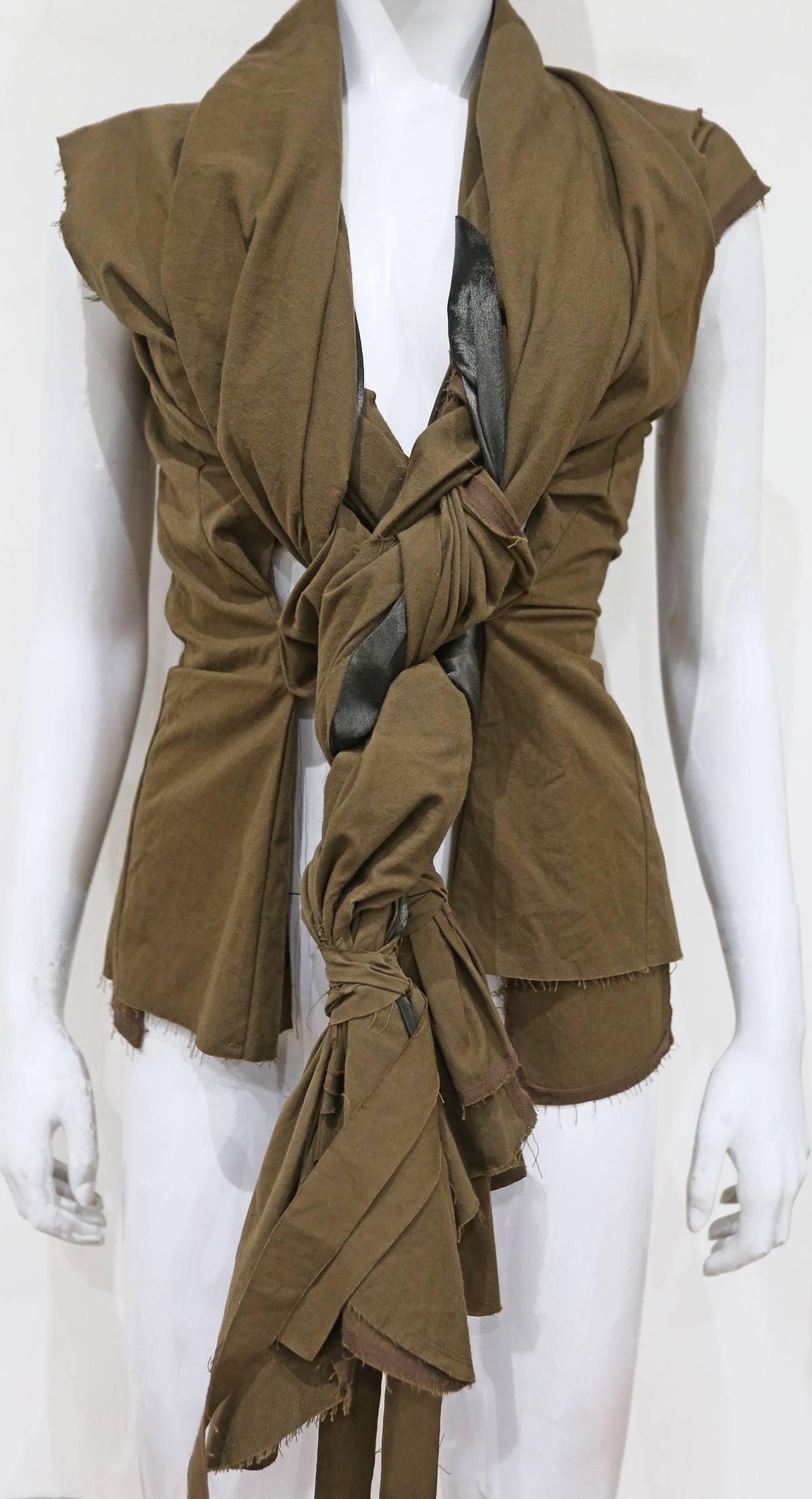 COMME des GARCONS khaki green bolero jacket from the SS 2003 collection. The jacket can be closed by plaiting the two braids together. 

