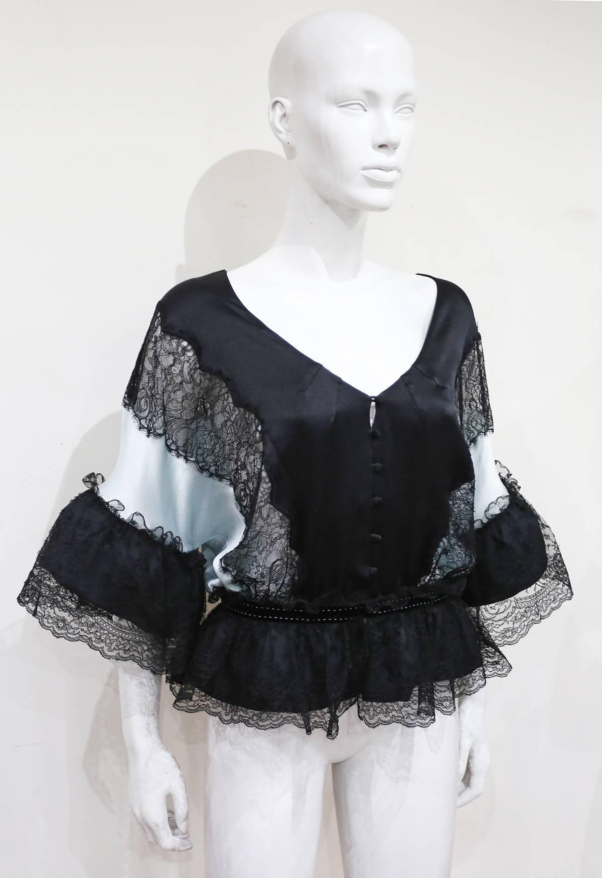 A beautiful evening blouse by La Perla. The blouse has diaphanous lace panels and frills and features a black velvet waist band. 

Italian 44 - French 40 - UK 12 