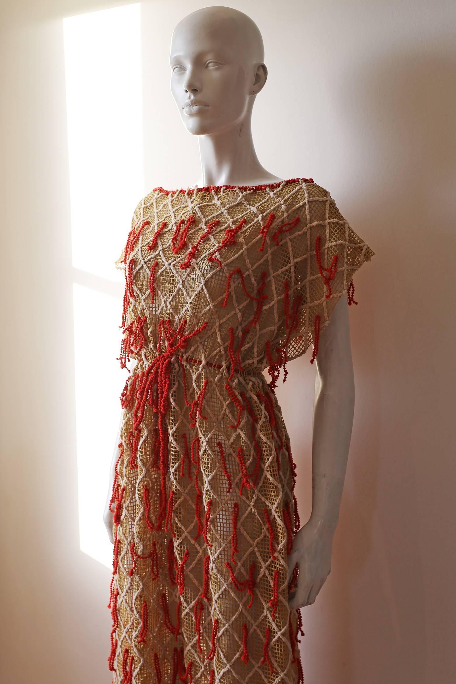 A beautiful and unique netted dress from the 1970s. The dress has a drawstring waist, beautiful checkered embroidery with fabric tassels all over. 

Size Small 