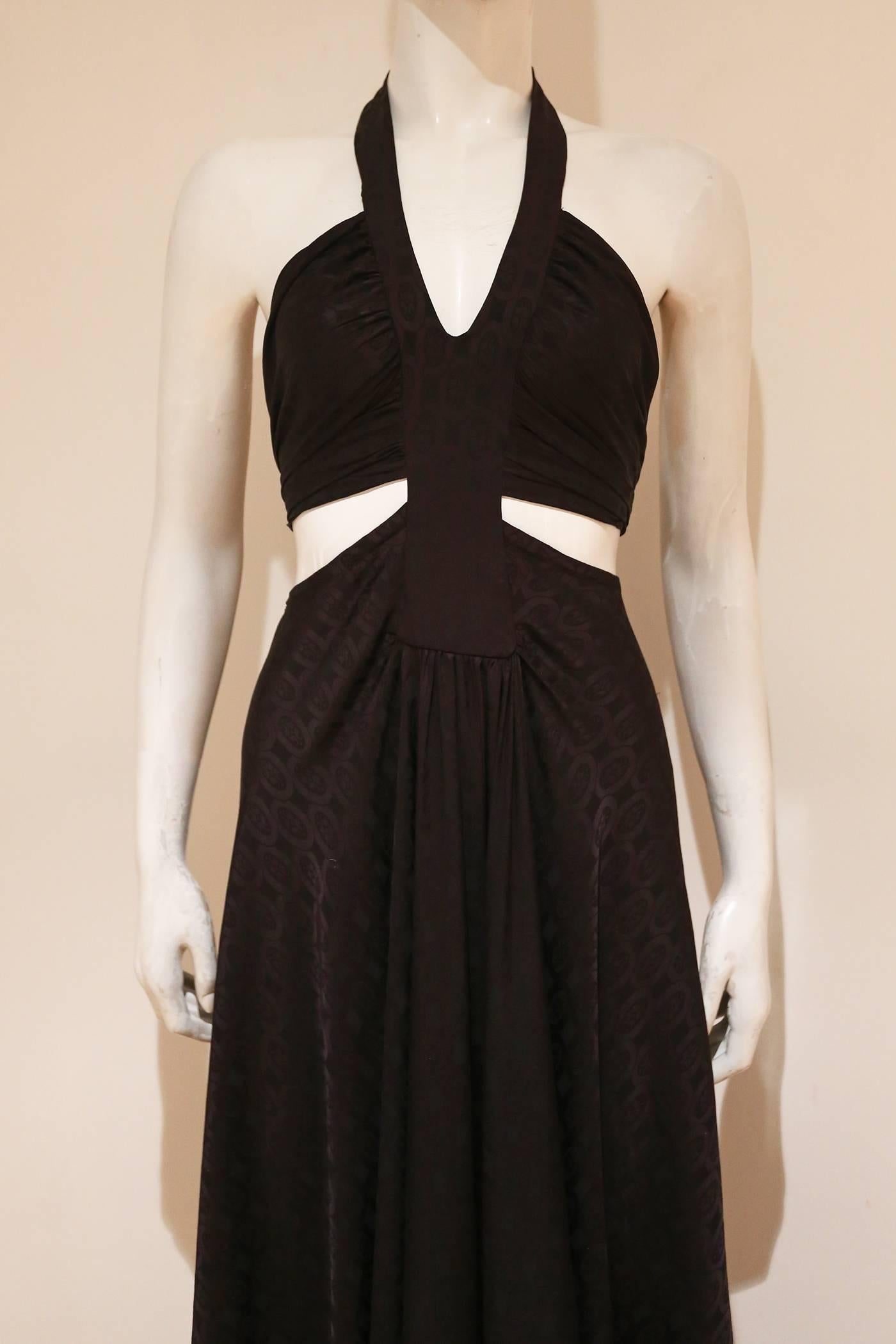 A beautiful and rare AnnaCat black halter-neck evening dress from the 1960s. The dress features a pleated skirt, low back and a bikini attached to the yoke with ties at the rear. 

Approx. UK 10-12  European 38-40

Annacat was the Biba of The