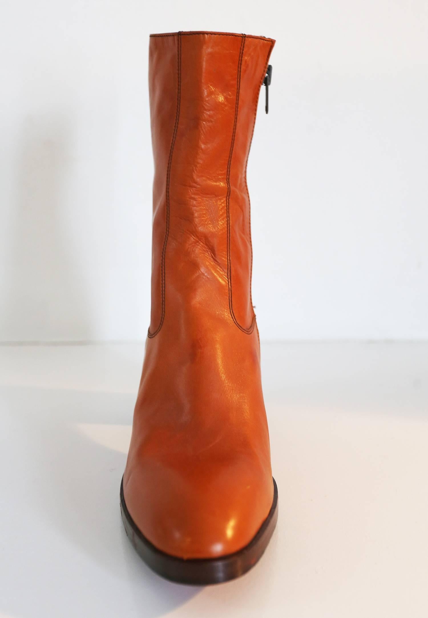 Original 1970s mens platform boots by Jocelyn. The boots are in orange high quality Italian leather and feature a round toe, wooden platform, red sole and side zipper. 

EU 43 


