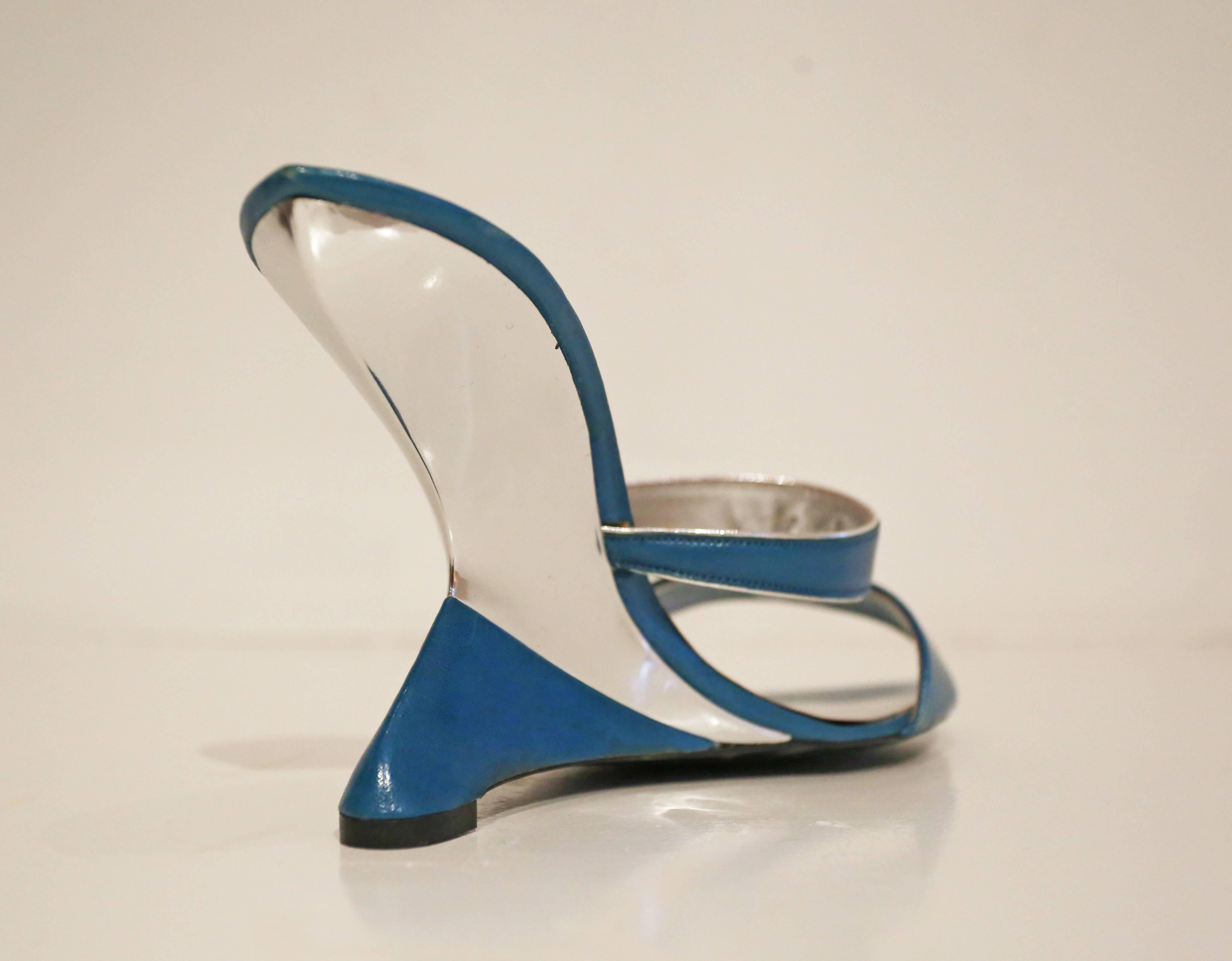 A pair of incredibly rare  Charles Jourdan wedge sandals, circa 1969–70. The shoes are in a turquoise and metallic silver leather and feature an avant-garde inwards wedge heel. These shoes are definitely ahead of their time!

Size 39 

Comes