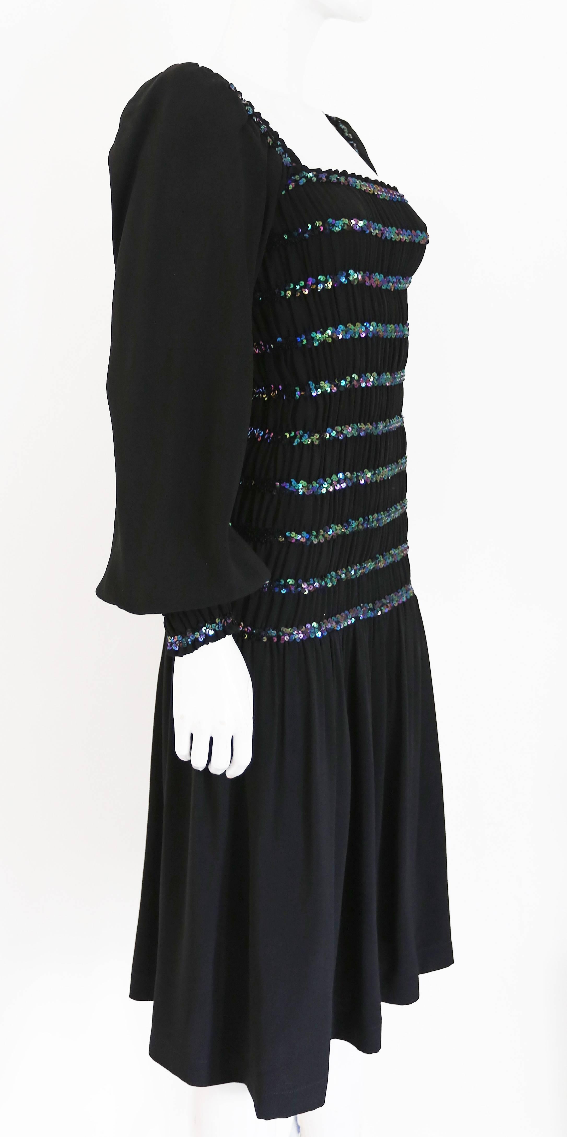 A Yves Saint Laurent party dress, circa 1976-77. The dress is smocked from shoulders to hips, has a square neckline, sequin embellishment and ruffled cuffs. 

Fr 36  UK 8  Small