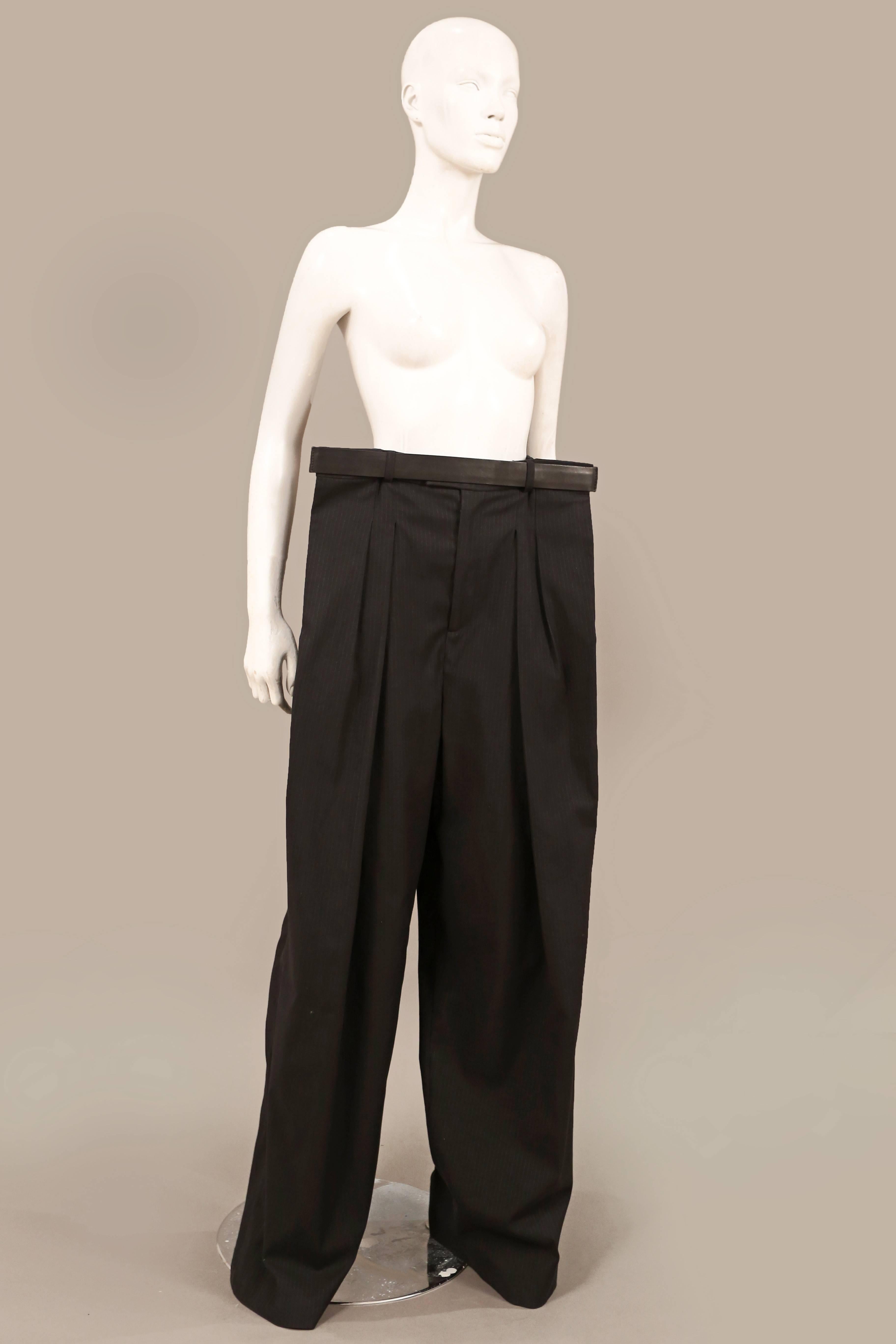 A pair of extremely rare Maison Martin Margiela extended wide leg pinstripe pants from the spring-summer 2011 runway collection. The pants features a super extended waist held together with a black leather belt, interior legging and elastic