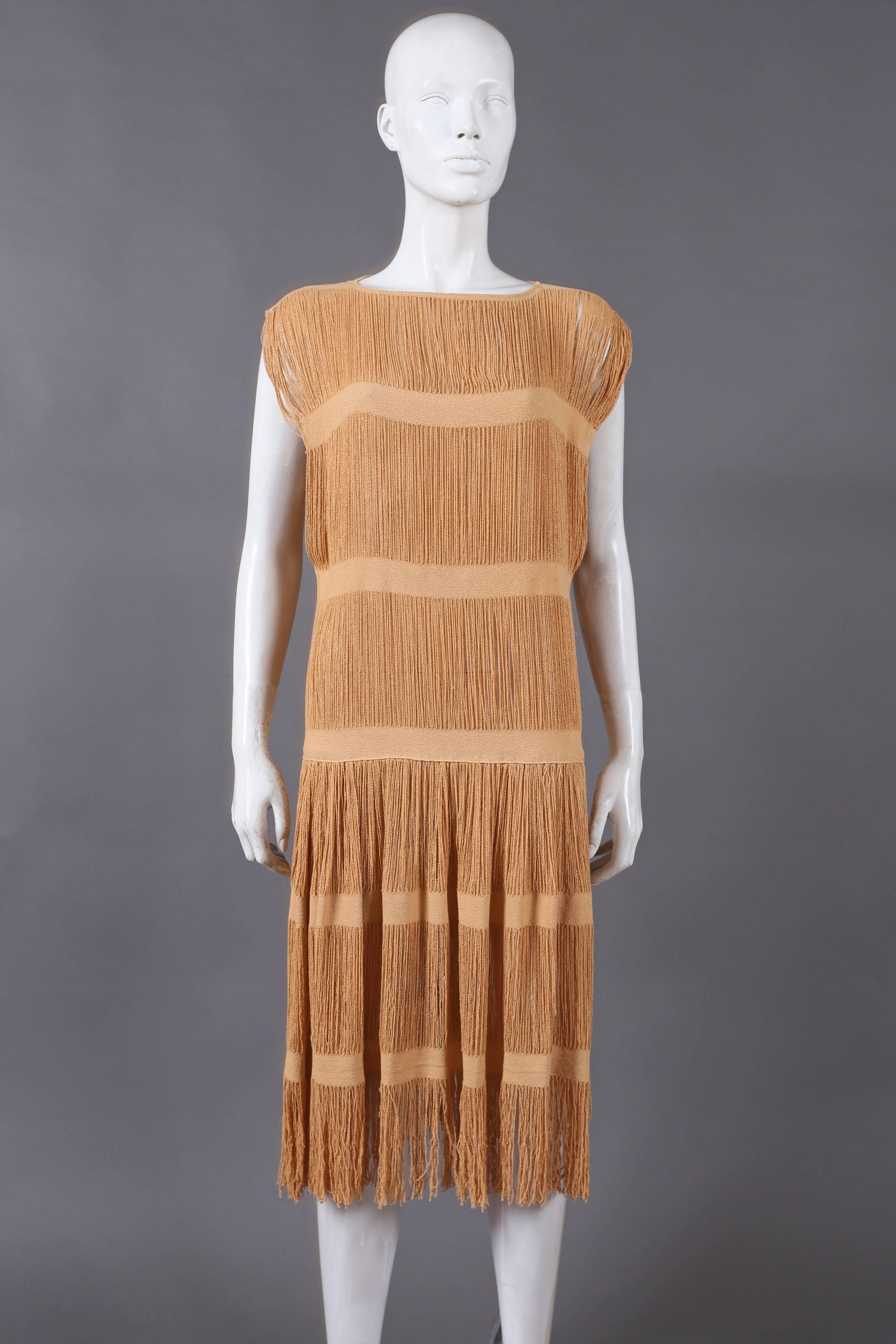 A beautiful linen flapper dress from the 1920s. The dress features 6 lien bands, fringed hem, high side slits and drop waist.

size small
